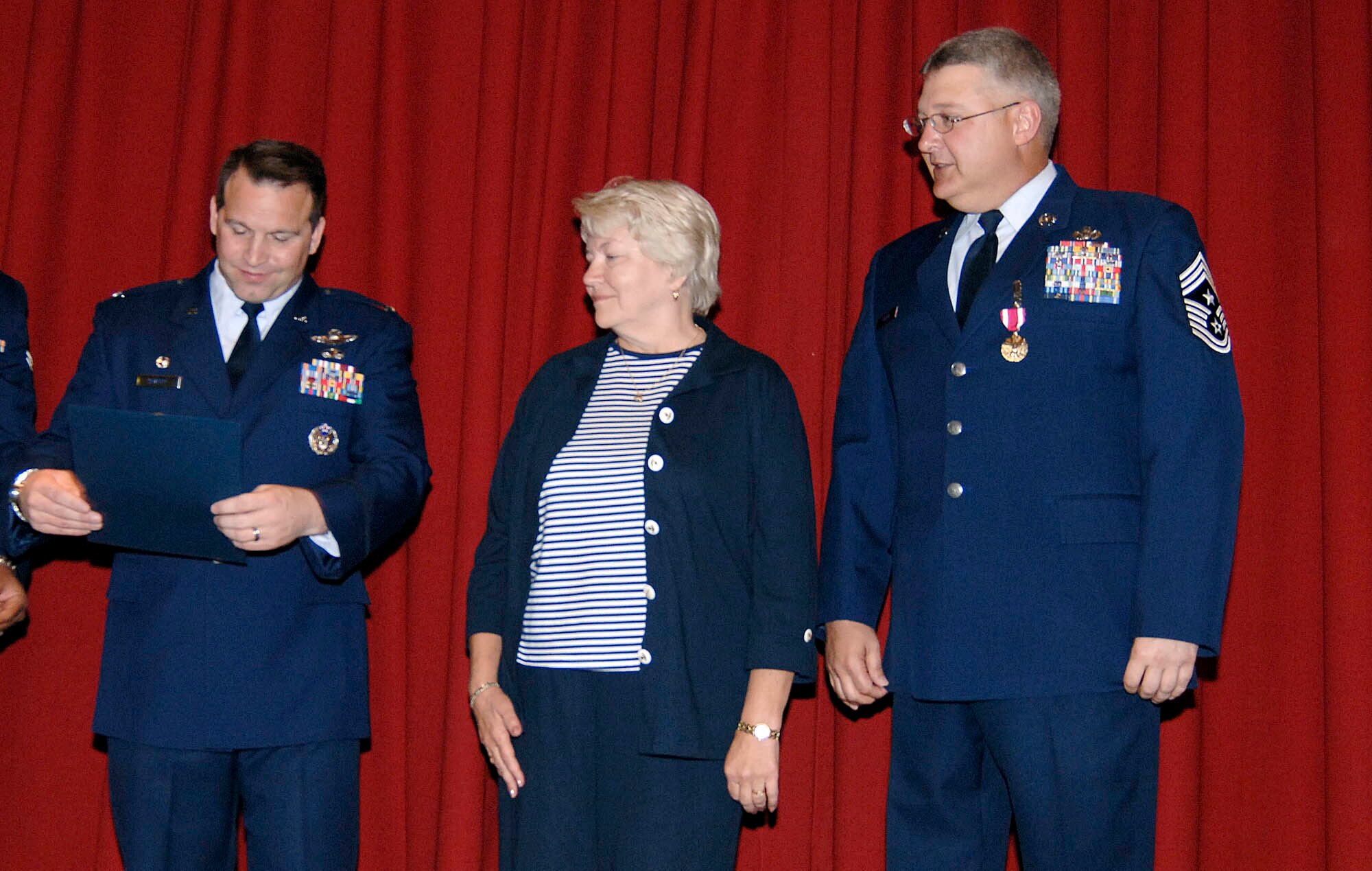 FAIRCHILD AIR FORCE BASE, Wash. – Col. Thomas Sharpy (left), 92nd Air Refueling Wing commander, presents Judith Frontiera a certificate of appreciation for her support and sacrifice throughout the 27-year Air Force career of her son, Chief Master Sgt. Paul Sikora (right), former 92nd ARW command chief. Mrs. Frontiera travelled from Andover, Mass., to attend Chief Sikora’s retirement ceremony June 12 at Club Fairchild here. (U.S. Air Force photo / Staff Sgt. JT May III)