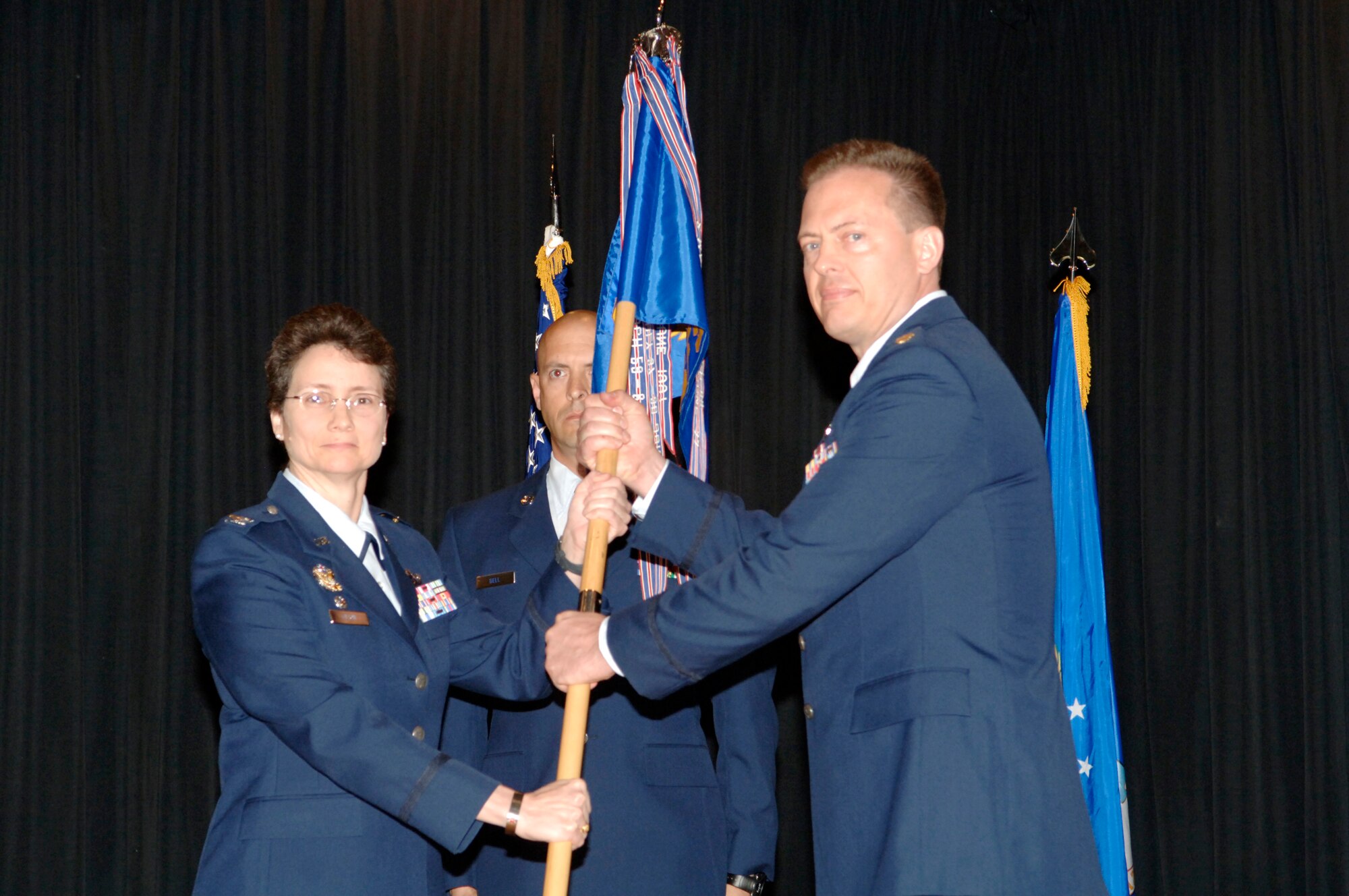 FAIRCHILD AIR FORCE BASE, Wash. – Col. Suzanne Filion, 92nd Mission Support Group commander, passes the 92nd Security Forces Squadron guidon to Maj. Jeffery Ditlevson, who took command from Lt. Col. Gerald Szybist at the Deel Community Center here June 12. (U.S. Air Force photo / Staff Sgt. Chad Watkins)