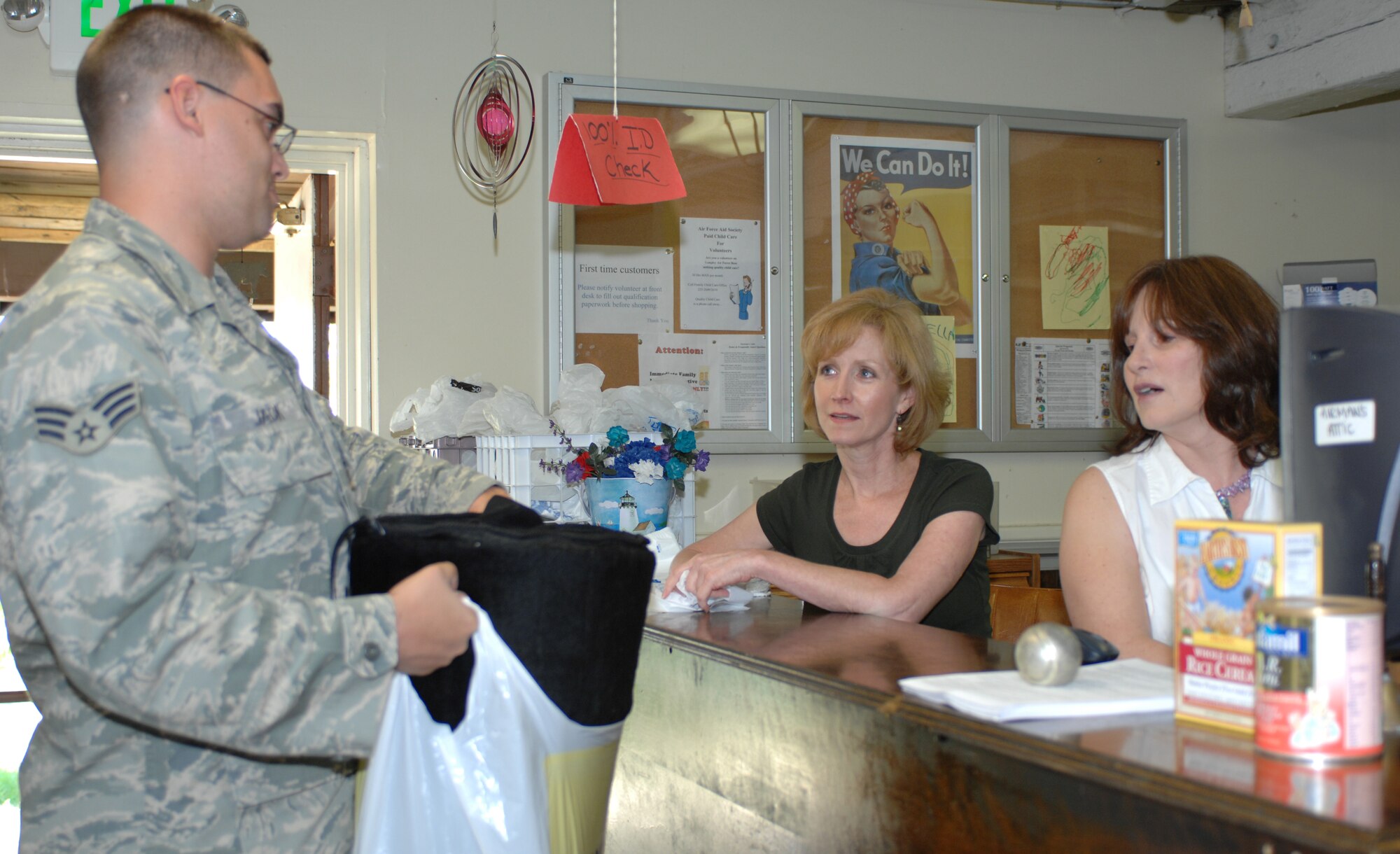 LANGLEY AIR FORCE BASE, Va. -- Mrs. Sara Andreano (middle) and Ms. Brenda Fisher (right) check out a free blanket from the Airman’s Attic for Senior Airman Ryan Jack, 1st Civil Engineer Squadron emergency management journeyman, June 12. Mrs. Andreano and Ms. Fisher have volunteered at the Airman’s Attic for more than seven years combined. (U.S. Air Force photo/Tech. Sgt April Wickes) 