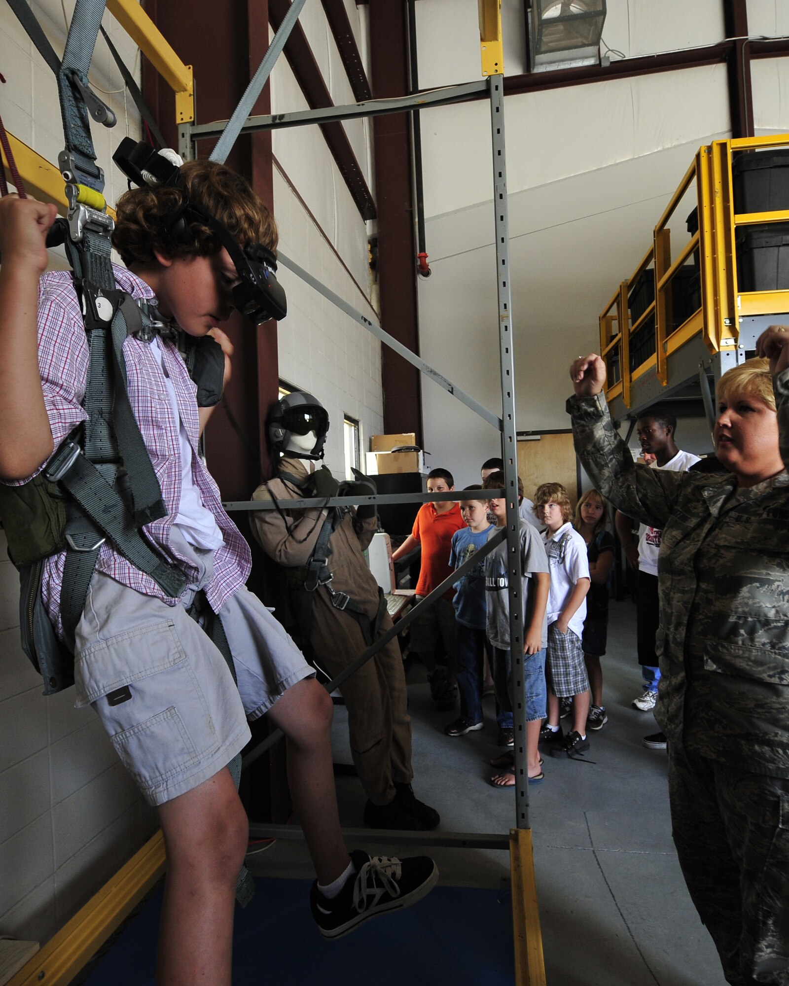 MOODY AIR FORCE BASE, Ga. -- Tech. Sgt. Sonya Couture, 23rd Operations Support Squadron aircrew flight equipment lead instructor, instructs a participant of the Lowndes County Sheriff's Office Drug Abuse Resistance Education camp on how to maneuver in the virtual reality parachute flight simulator as other participants watch his progress here June 11. The D.A.R.E. camp toured many units on Moody Air Force Base and learned about many interesting career fields. (U.S. Air Force photo by Senior Airman Elizabeth Rissmiller)
