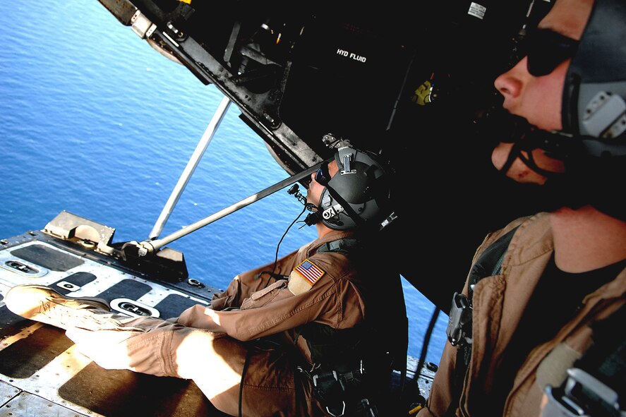 Airman 1st Class Nicholas Greer and Senior Airman Martin Smith watch a smoke grenade fall to the water from the back ramp of an HC-130 Hercules June 3 during a mission off the coast of Djibouti. Both are loadmasters from the 71st Search and Rescue Squadron out of Moody Air Force Base, Ga. The Airmen are deployed to Combined Joint Task Force-Horn of Africa out of Camp Lemonier, Djibouti. (U.S. Air Force photo/Tech. Sgt. Jeremy T. Lock) 
