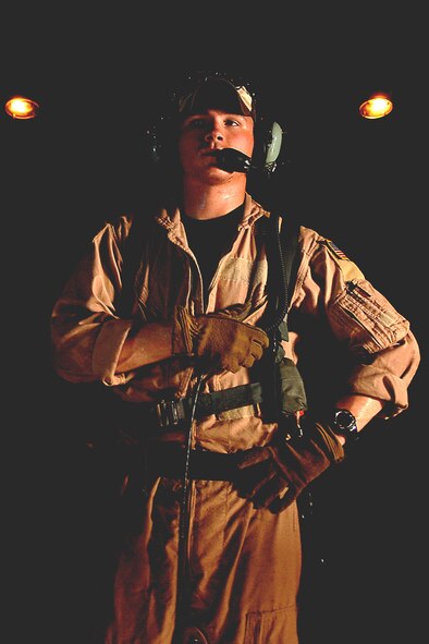 Senior Airman Martin Smith prepares to put on his harness before opening the back ramp of an HC-130 Hercules during a mission June 3 off the coast of Djibouti. Airman Smith is deployed to Combined Joint Task Force-Horn of Africa out of Camp Lemonier, Djibouti. The Airman is an aircraft loadmaster from the 71st Search and Rescue Squadron at Moody Air Force Base, Ga. (U.S. Air Force photo/Tech. Sgt. Jeremy T. Lock)