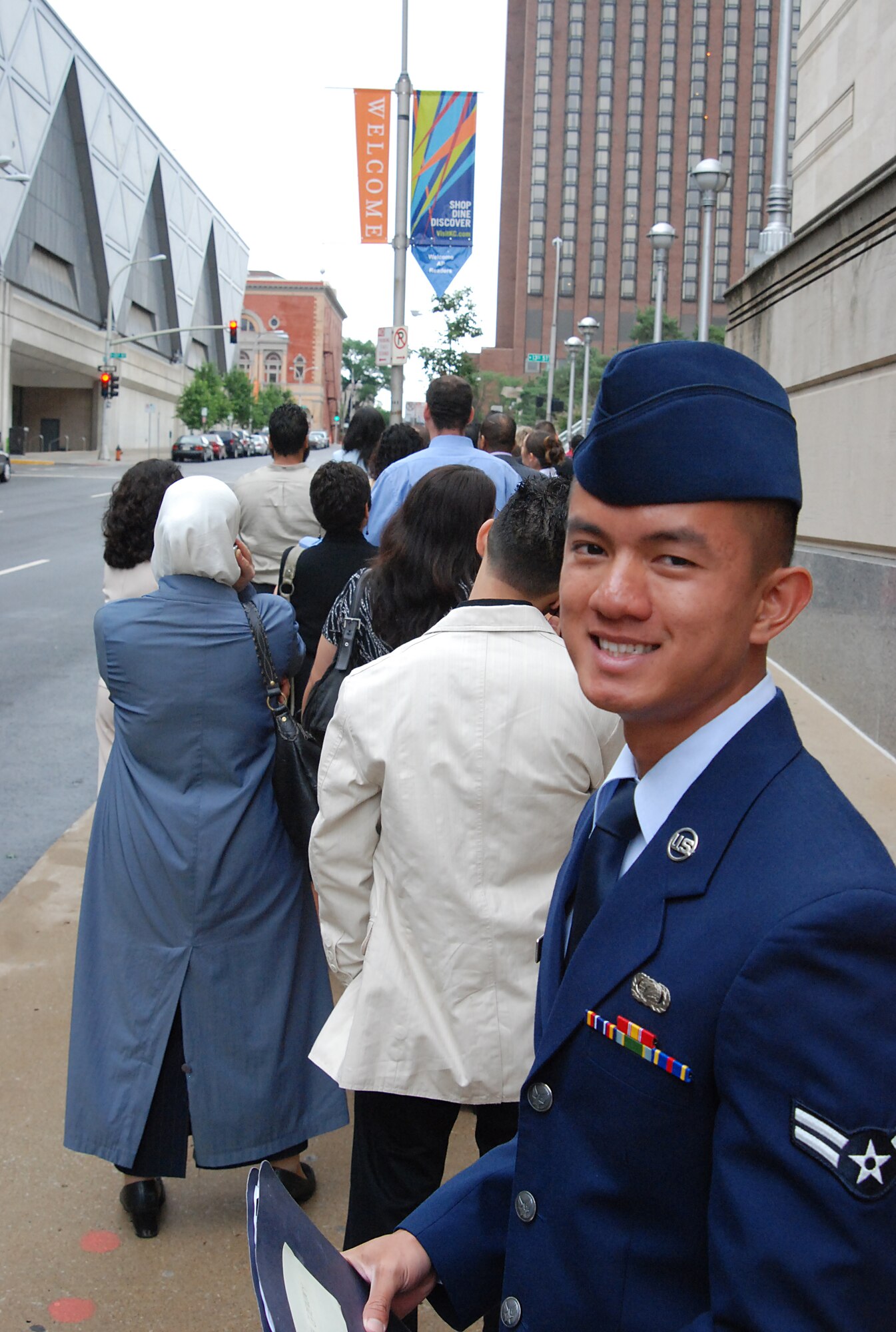 KANSAS CITY, Mo. -- Airman 1st Class Thanh Tran, 22nd Air Refueling Wing, waits at the end of a long line of immigrants who will become American citizens during a naturalization ceremony, at the Municipal Auditorium, June 9. Airman Tran and almost 1,080 people representing 142 countries became citizens in western Missouri’s largest naturalization ceremony. (photo by Airman 1st  Class Jessica Lockoski)