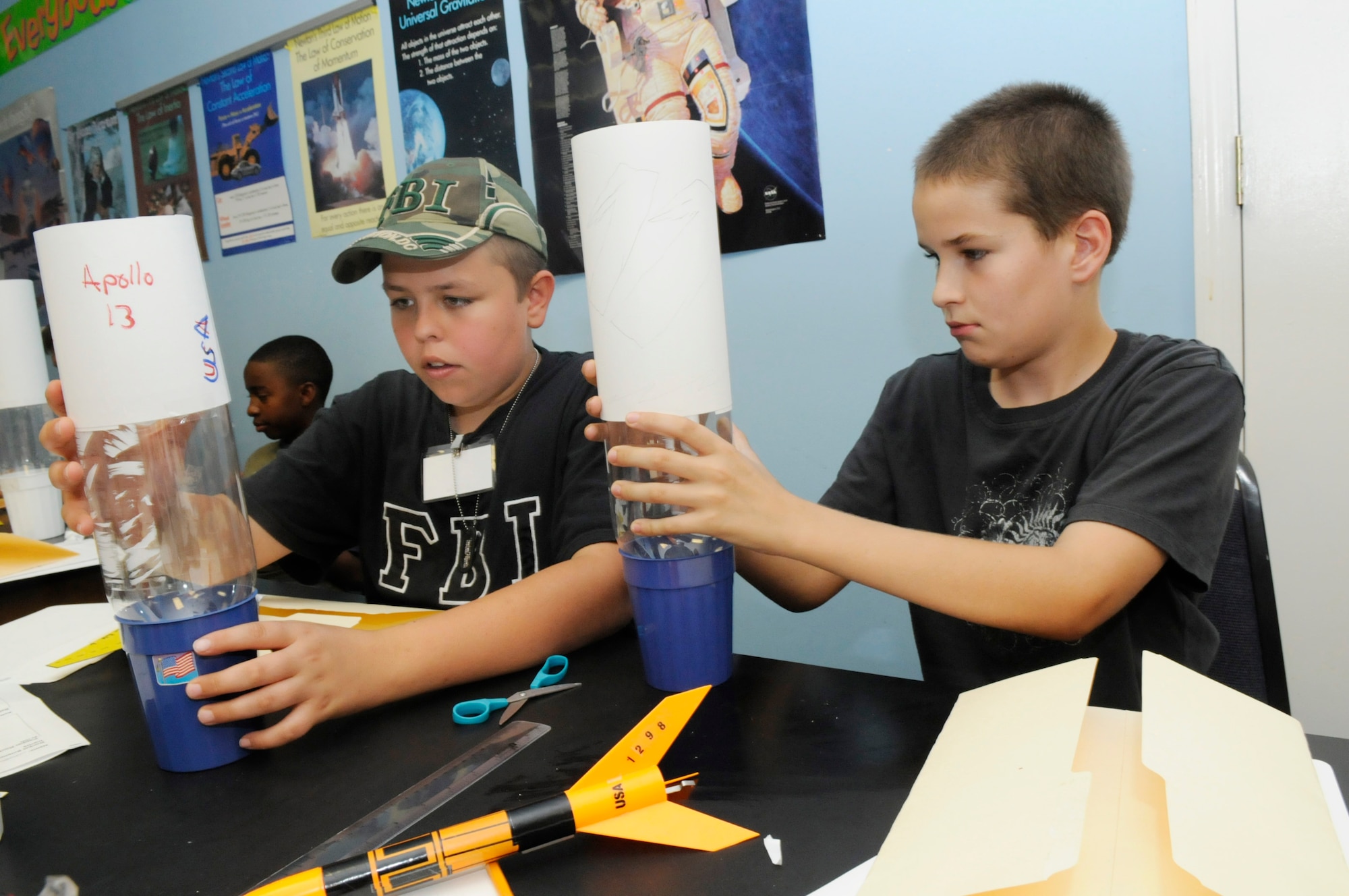 Chipper Messer and Eddie Henning III, build bottle rockets, which will be liquid propelled, in the Rocket Science class June 5.  U. S. Air Force photo by Sue Sapp