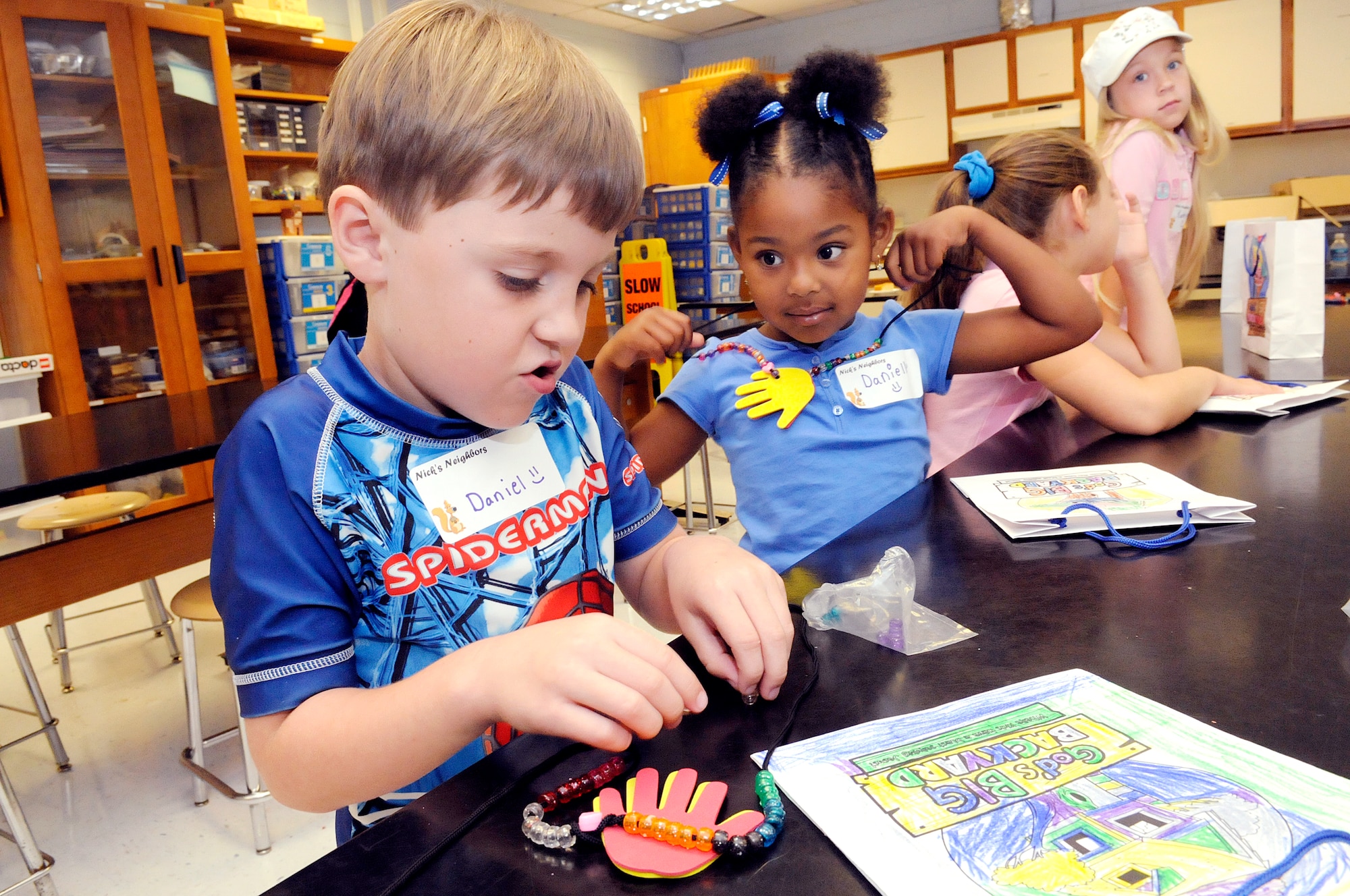 Daniel Sahm, 6, and Danielle McTeer, 5, finish making helping hands necklaces diring arts and crafts at vacation bible school June 10. U. S. Air Force photo by Sue Sapp
