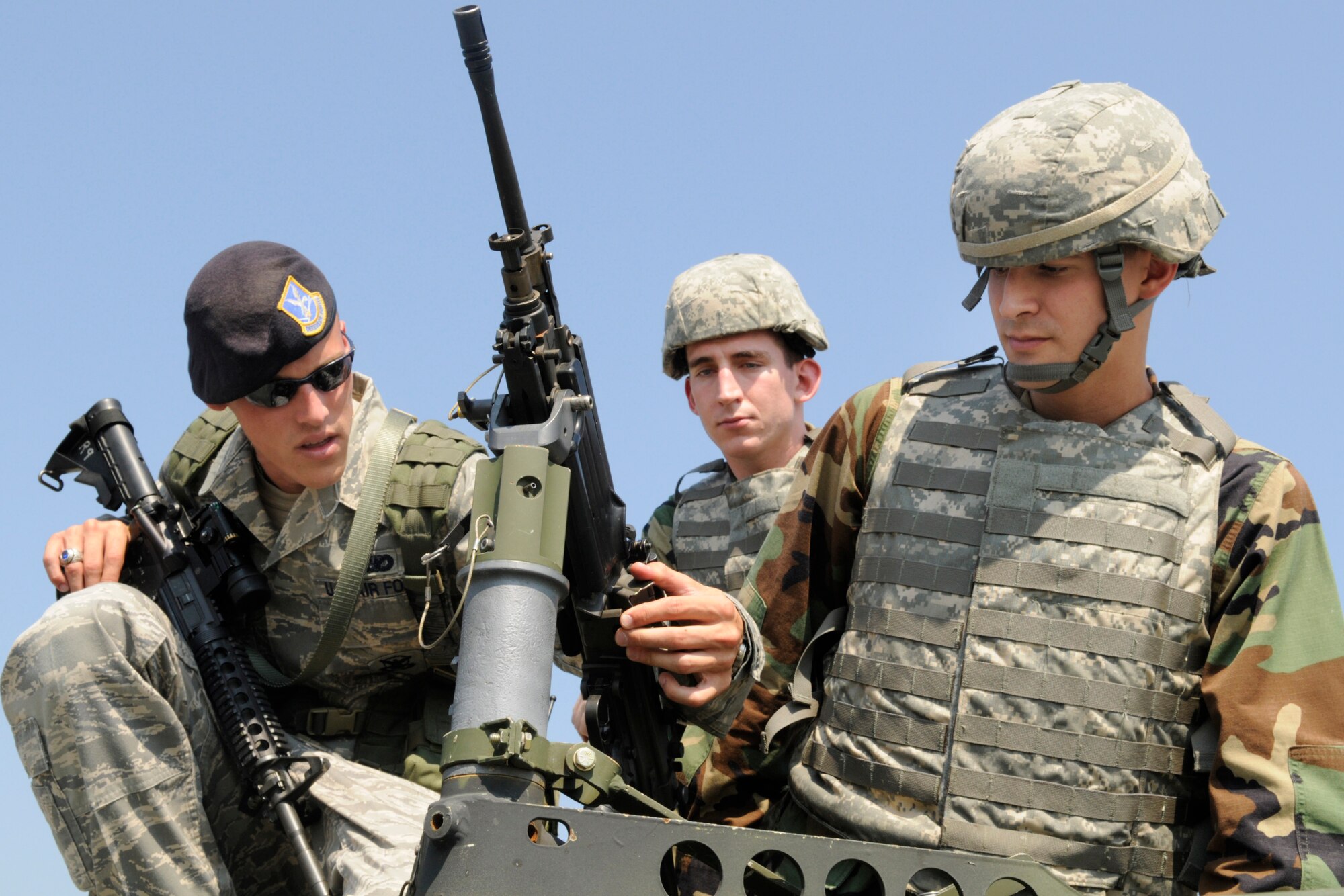 Senior Airman Jonathan Leon, 78th Security Forces Squadron, shows Cadets Nick Mercier and Bernabe Tucker an M249 squad assault weapon atop a humvee. U. S. Air Force photo by Sue Sapp