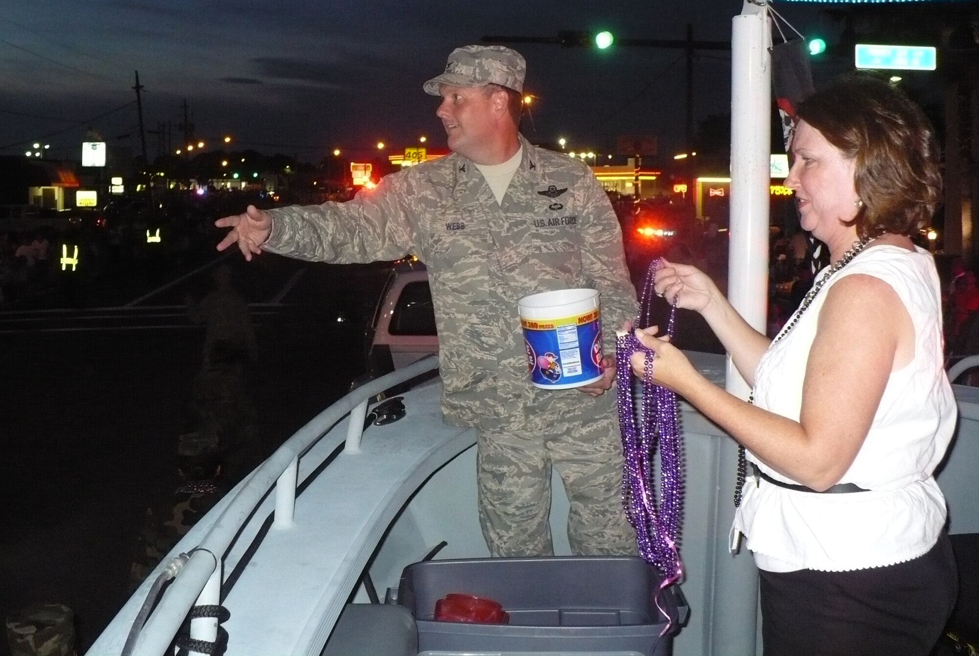 Col. Brad Webb, 1st Special Operations Wing commander, and his wife, Dawna, toss candy and beads to the crowd along Eglin Parkway during the Billy Bowlegs parade June 9. Colonel and Mrs. Webb traveled the parade route in a 40-foot range support boat used for maritime training. 