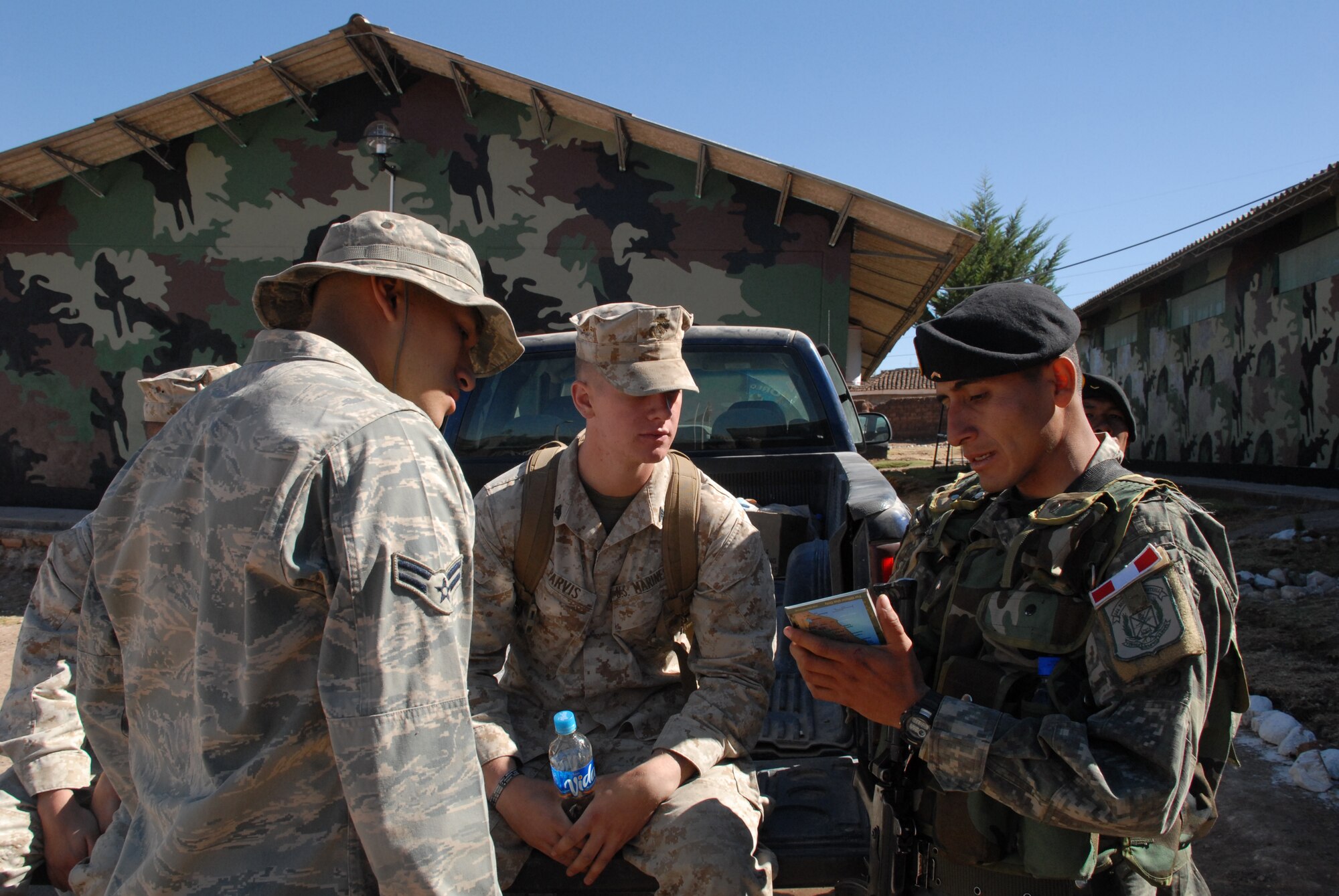 A Peruvian soldier explains the Peruvian rank structure to U.S. Marine Sgt. Alan Parvis, deployed from the 4th Civil Affairs Group at Anacostia Naval Annex, District of Columbia, and Airman 1st Class George Monroe, deployed from Tinker Air Force Base, Okla., June 6, during a visit to Huanta, Peru, the construction site where wells are being built in support of New Horizons Peru 2008, a humanitarian event that benefits underprivileged Peruvians. U.S. Air Force, Army, Marines, and Navy servicemembers came together to build new schools, clinics, and water wells which will accommodate nearly 5,200 Peruvians. (U.S. Air Force photo/Airman 1st Class Tracie Forte)