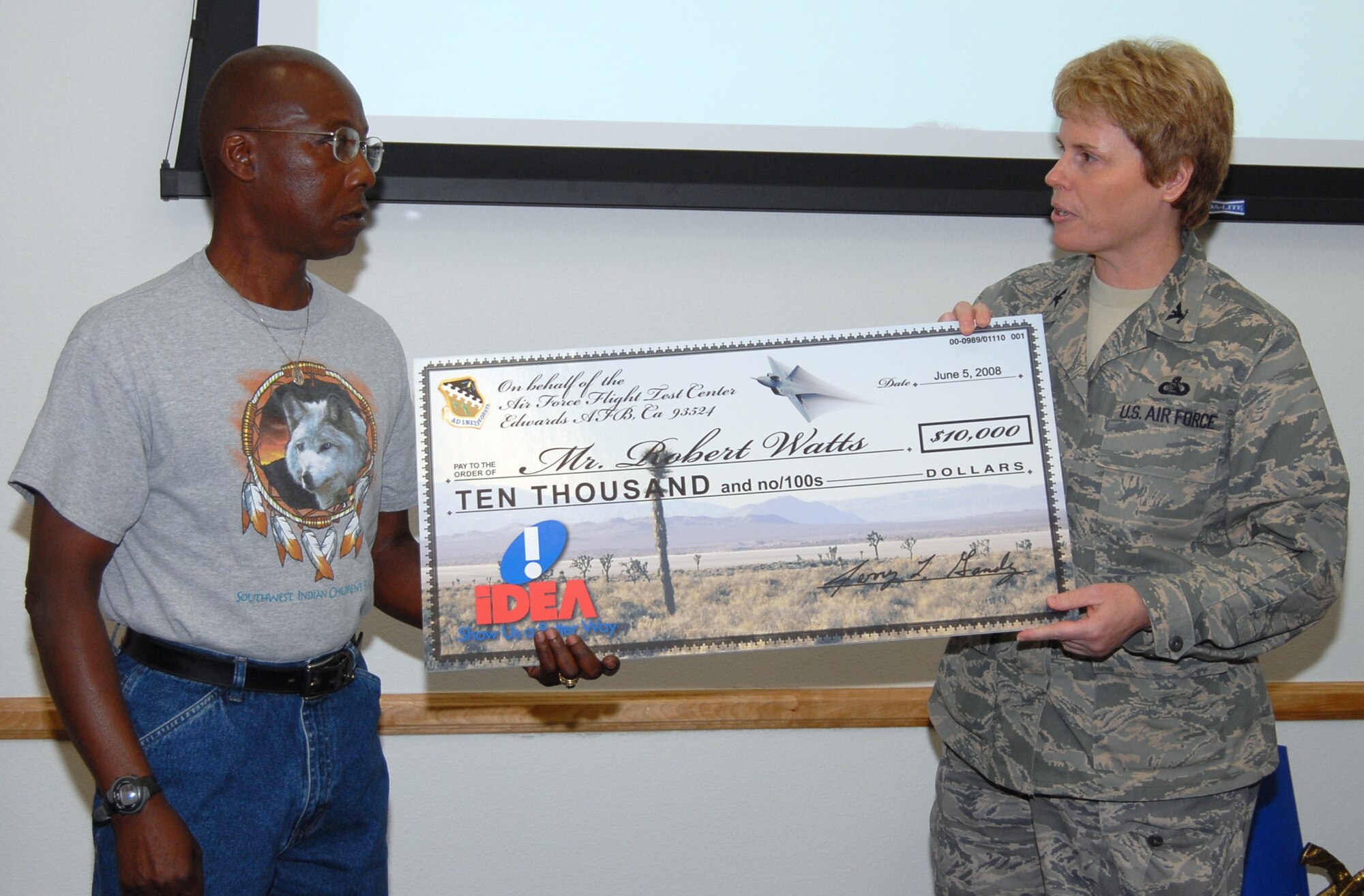 Robert Watts (left), 412th Maintenance Squadron ordnance inspector, receives a $10,000 check June 11 from Col. Nancy Wharton, 95th Air Base Wing vice commander. Mr. Watts received the check for an idea he submitted to the Innovative Development through Employee Awareness program. His idea was to allow the egress shop at Edwards to repair F-16 Fighting Falcon canopies instead of sending them out to depot shops. (Air Force photo by Senior Airman Stacy Sanchez)