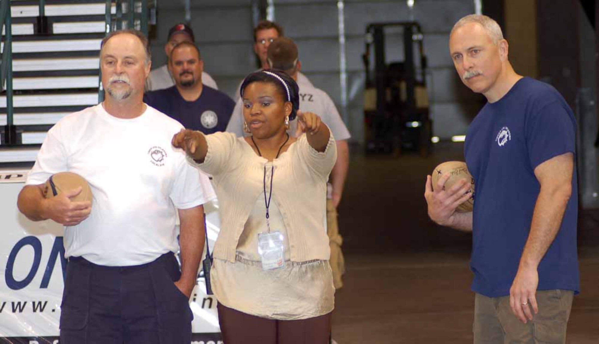 Jasmine Hall, Oklahoma City Yard Dawgz director of game operations, discusses the rules of the obstacle course with Rick Stuart, AFGE Local 916 vice president, left, and John Over, Oklahoma City Air Logistics Center executive director, during a wellness challenge event at the Ford Center May 31.  The event took place prior to the Military Appreciation Night hosted by the Yard Dawgz.  (Air Force photo by John E. Banks)