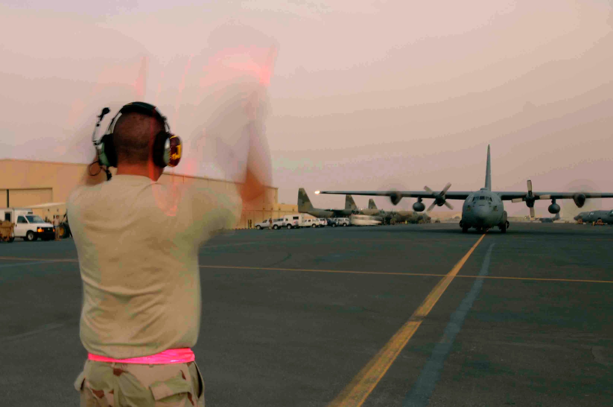 SOUTHWEST ASIA - Staff Sgt. Jonathan Osheim, 379th Expeditionary Airlift Maintenance Squadron, guides a C-130 aircraft into its final parking position on the ramp at a Southwest Asia air base after returning from a mission June 11.  Sergeant Osheim and his team will completely inspect, refuel, and prepare aircraft for its next mission. He is deployed from Pope Air Force Base, N.C. (U.S. Air Force photos/Tech. Sgt. Johnny Saldivar)

