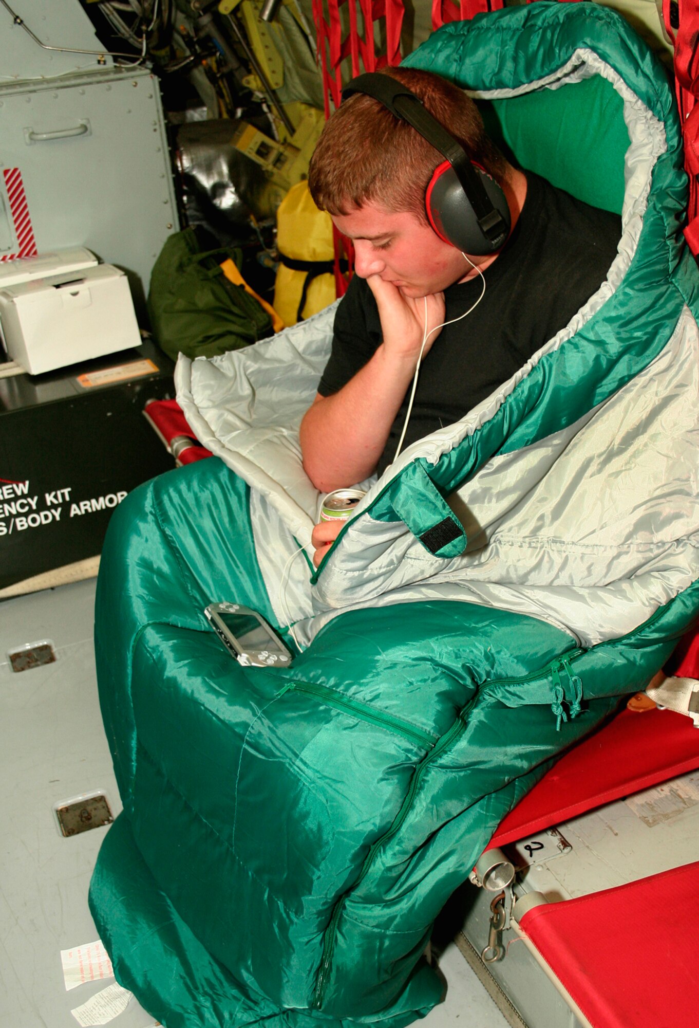 GRISSOM AIR RESERVE BASE, Ind., -- Senior Airman Trevor Eikenberry, a hydraulics technician with the 434th  Maintenance Squadron, does all he can to stay warm while trying to pass the time listening to music on the long flight from Incirlik Air Base, Turkey back to Grissom. Airmen Eikenberry and other members of the 434th Air Refueling Wing are providing refueling support to military operations in the region.  (U.S. Air Force Photo/Tech. Sgt. Patrick Kuminecz)