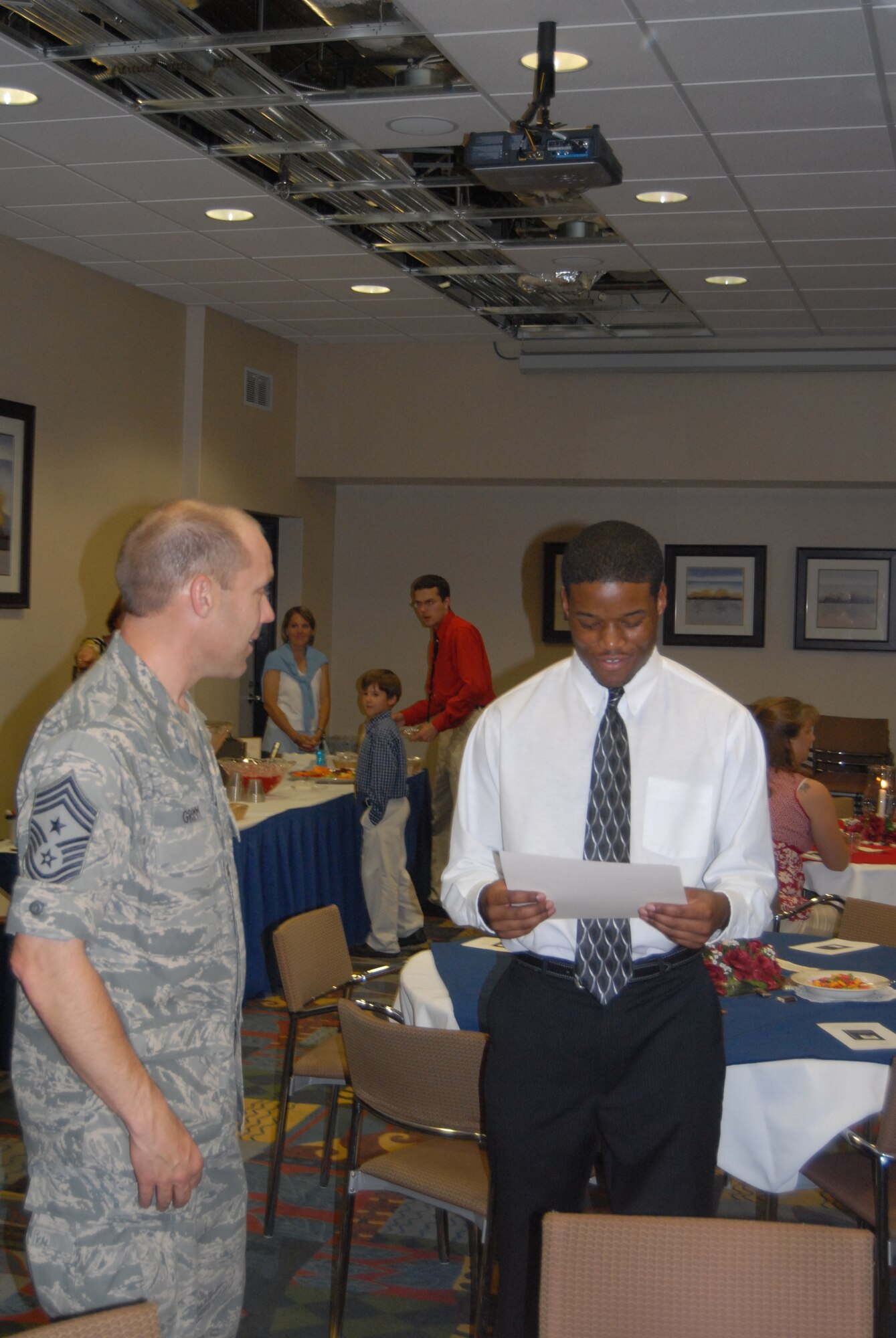 Chief Master Sgt. Michael Grimm, 43rd Airlift Wing Command Chief, talks with Brandon Niles at the Pope Scholarship banquet June 3 at the Community Activities Center. (U.S. Air Force Photo by 2nd Lt. Chris Hoyler)