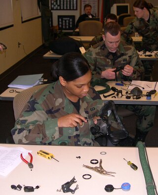 Airman 1st Class Latoya Singleton, 305th Operations Support Squadron, assembles a Quick Don Mask prototype, designed to provide an advanced protective integration of the eyes and nose, for the Air Mobility Command Test and Evaluation Squadron recently at McGuire AFB, N.J.  (U.S. Air Force photo/Senior Master Sgt. Cliffton Herndon)