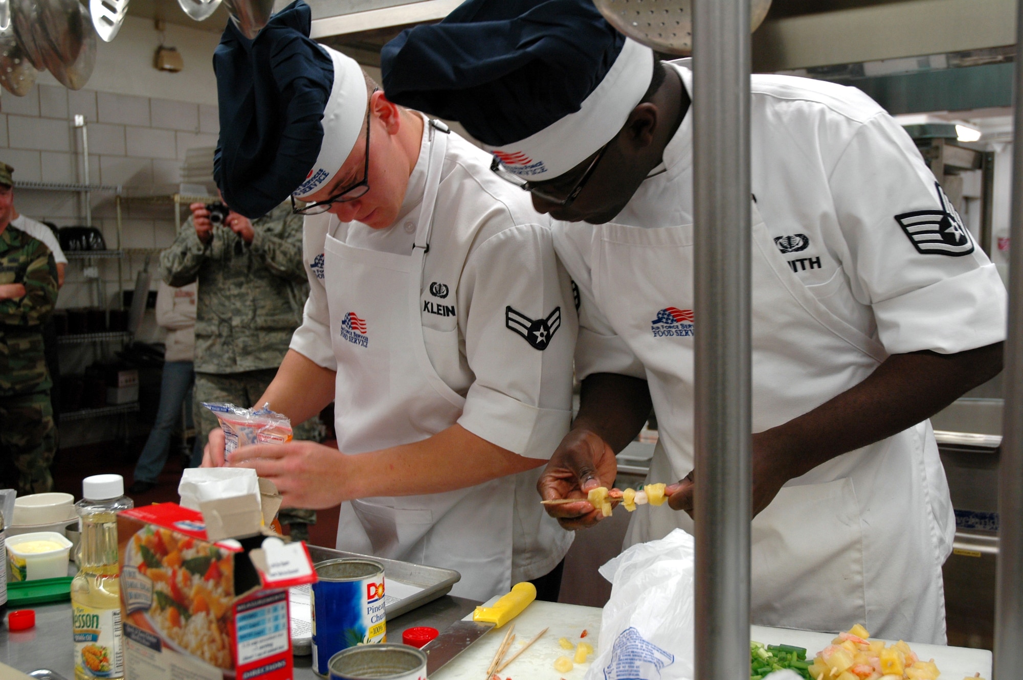 Airman 1st Class Joe Klein and Staff Sgt. Jeremy Smith, 12th Missile Squadron chefs, prepare their award-winning Asian barbecue shrimp with coconut rice during this quarter's Warrior Chef competition at the Elkhorn Dining Facility June 10. (U.S. Air Force photo/Airman 1st Class Emerald Ralston)