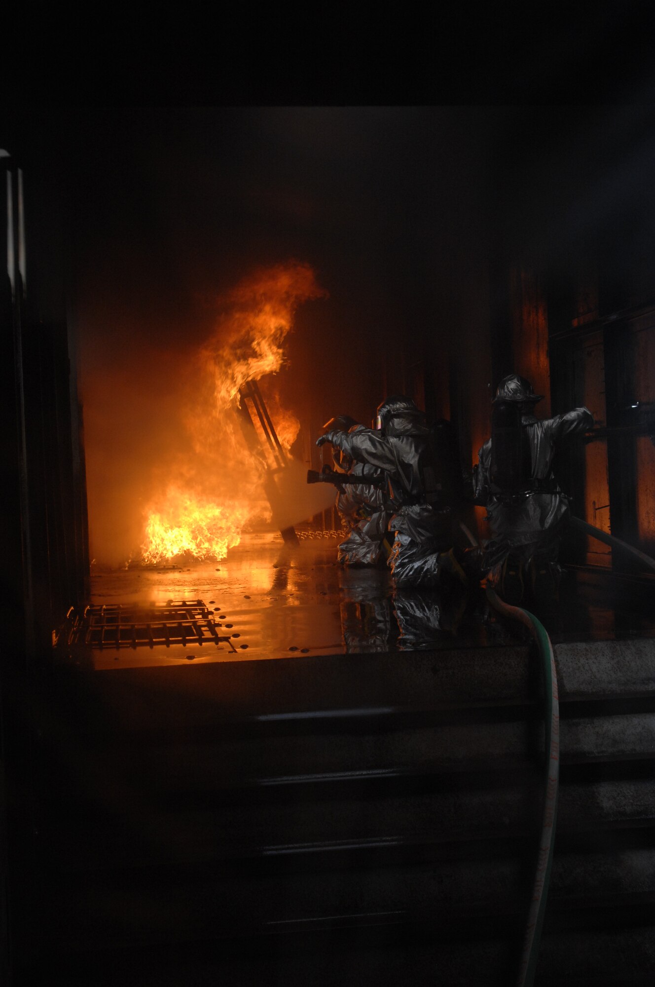 Firefighters from RAF Mildenhall, RAF Lakenheath, and Lajes Field came together  to battle the flames in a simulated aircraft  at the regional USAFE Fire trainer at RAF Mildenhall May 22 2008.  Firefighters are required to participate in live fire training twice a year.  (U.S. Air Force Photo by Senior Airman Heather K. Stidham)