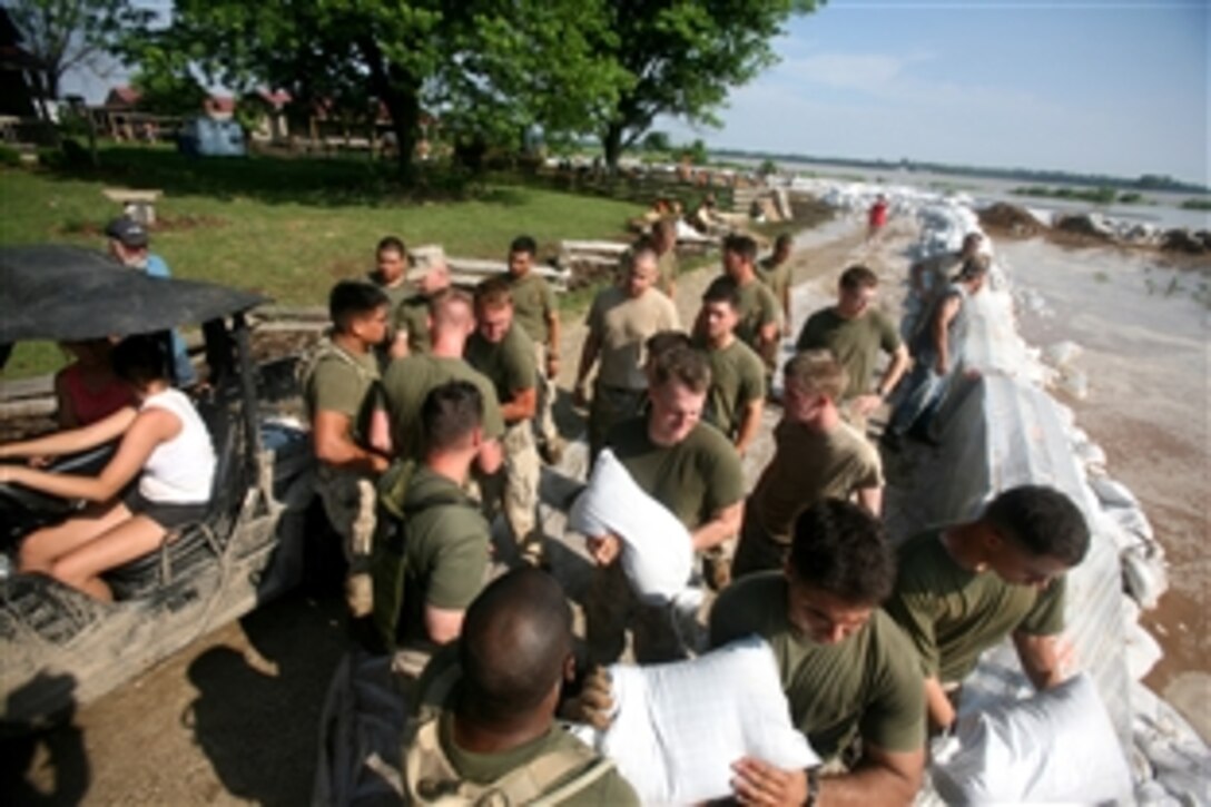 Marines and sailors of 26th Marine Expeditionary Unit stack sand bags to reinforce the levees June 9, 2008, in Elnora, Ind.  Local authorities in Elnora requested the 26th MEU provide support to reinforce the levees from flooding of the White River. 