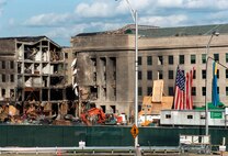 The American Flag, draped over the wall of the Pentagon by firemen and military personnel on the day after the Sept. 11th terrorist attack, is lowered on Oct. 11, 2001. The ceremonial lowering, exactly one month after the terrorist attack was performed by a team of U.S. Army soldiers from the Military District of Washington. Defense Department photo by R. D. Ward.