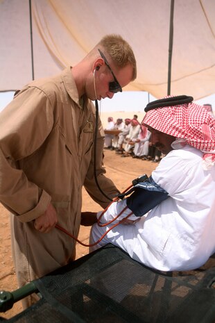 Seaman Scott Wiley, 26, a line corpsmen from Portland, Ore., with Headquarters and Service Company, 2nd Light Armored Reconnaissance Battalion, Regimental Combat Team 5, checks the blood pressure of Shaati Duad Asi, 47, a resident of Nathara, Iraq, during a medical assistance operation in the village June 12. The corpsmen and surgeons from units attached to Multi-National Force- West, Iraq, provided medical care all day for sicknesses ranging from high-blood pressure to tonsillitis until each resident was seen by a certified surgeon and cared for.