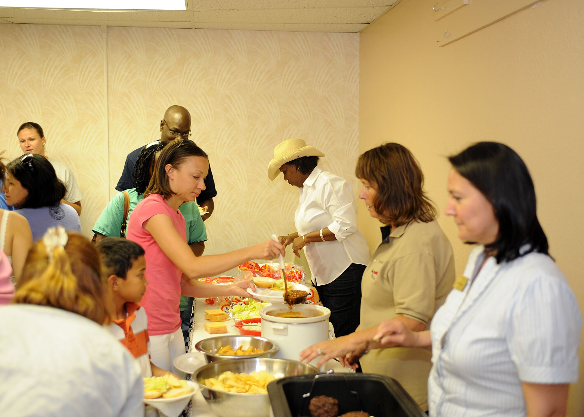 Employee's from the Airman and Familiy Readiness Center serve dinner to deployed spouses and their children at the Airman and Family Readiness Center on Holloman Air Force Base, N.M. Wednesday, June 11. The Families Apart dinner was meant to show support to the families of our military members. (U.S Air Force photo/ Airman 1st Class Deandre Curtiss)