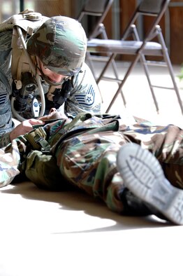 Staff Sgt. Jesse Bosch, 28th Medical Group aerospace medical technician, performs buddy care on Tech. Sgt. Dewayne Brown, 28th Medical Group NCO in charge of medical logistics at Camp Rapid, Rapid City, S.D., June 9, during a first-aid course. The course took place during the Golden Coyote joint training exercise. (U.S. Air Force photo/Airman Matthew Flynn)