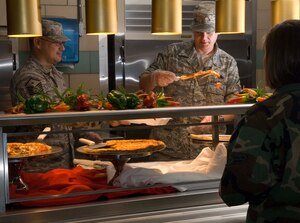 LANGLEY AIR FORCE BASE, Va. -- Master Sgts. Kraig Nadjkovic (left), 83rd Network Operations Squadron first sergeant, and Michael Dyer, 1st Aircraft Maintenance Squadron first sergeant, serve pizza at the Eagle Room Dining Facility here June 12.  Langley first sergeants often volunteer to serve pizza onThursdays. (U.S. Air Force photo/Senior Airman Barry Loo)