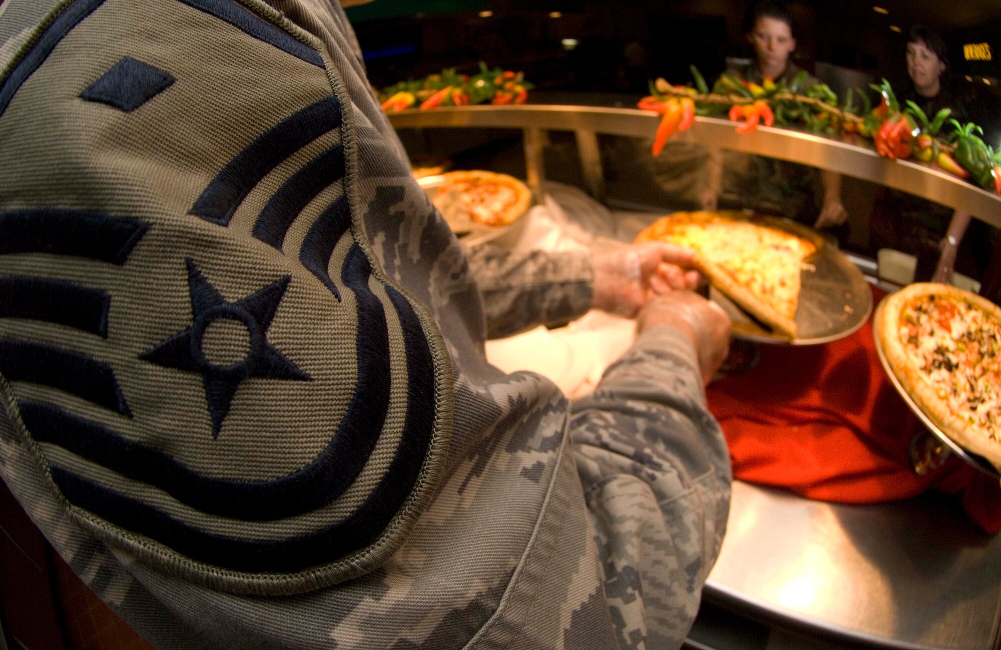 LANGLEY AIR FORCE BASE, Va. -- Master Sgt. Kraig Nadjkovic, 83rd Network Operations Squadron first sergeant, serves pizza to Airmen at the Eagle Room Dining Facility here June 12.  Langley first sergeants often volunteer to serve pizza on Thursdays. (U.S. Air Force photo/Senior Airman Barry Loo)