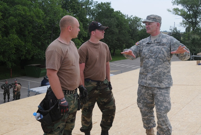 The North Dakota Adjutant General, Maj. Gen. David A. Sprynczynatyk (right), took to the roof to talk with Senior Airman Austin Roller (left) and Senior Airman Jared Kuhn, both with the 119th Civil Engineering Squadron.  The Airmen are currently deployed to Romania as part of Joint Task Force-East. (Photo by Sgt. Maj. Kimberly Williams)