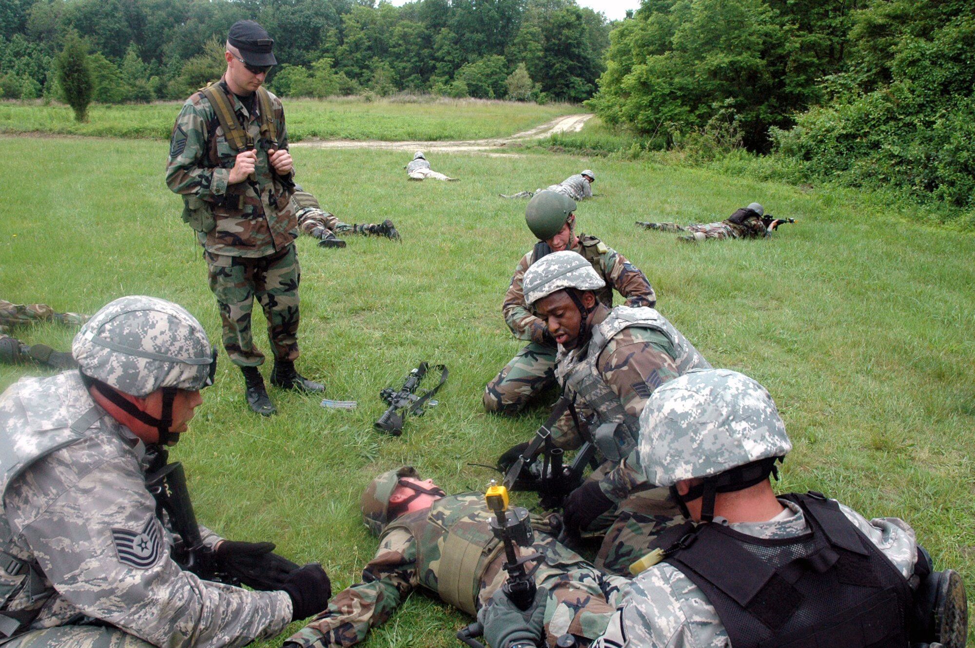 Instructor Master Sgt. Colby Bowers observes studenst in the Air Force Phoenix Warrior Training Course 08-5 prepare a "victim" for transport during training in a combat first aid class on a Fort Dix, N.J., range June 5, 2008.  The course is taught by the U.S. Air Force Expeditionary Center's Expeditionary Operations School and 421st Combat Training Squadron and prepares security forces Airmen for upcoming deployments. Annually, the USAF EC trains more than 23,000 students in expeditionary- and mobility air force-based courses both with in-residence and distance learning.  (U.S. Air Force Photo/Tech. Sgt. Scott T. Sturkol)