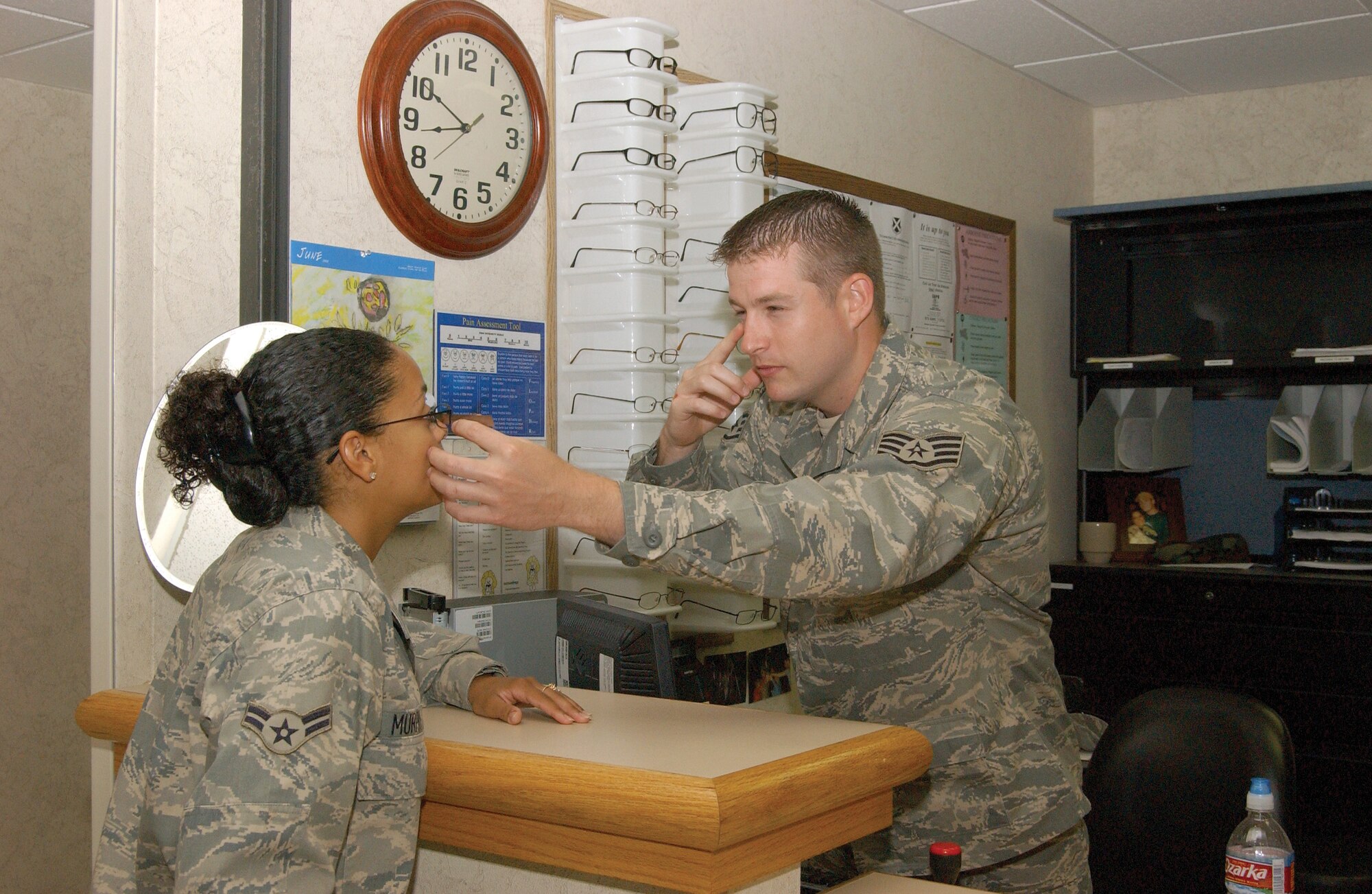 Staff Sgt. Adam Smith fits a pair of glasses on Airman 1st Class Tatiana Murphy. Sergeant Smith, with the 37th Aerospace Medicine Squadron, was recently named the 2007 Air Force Ophthalmic Technician of the Year. (U.S. Air Force photo/Alan Boedeker)
