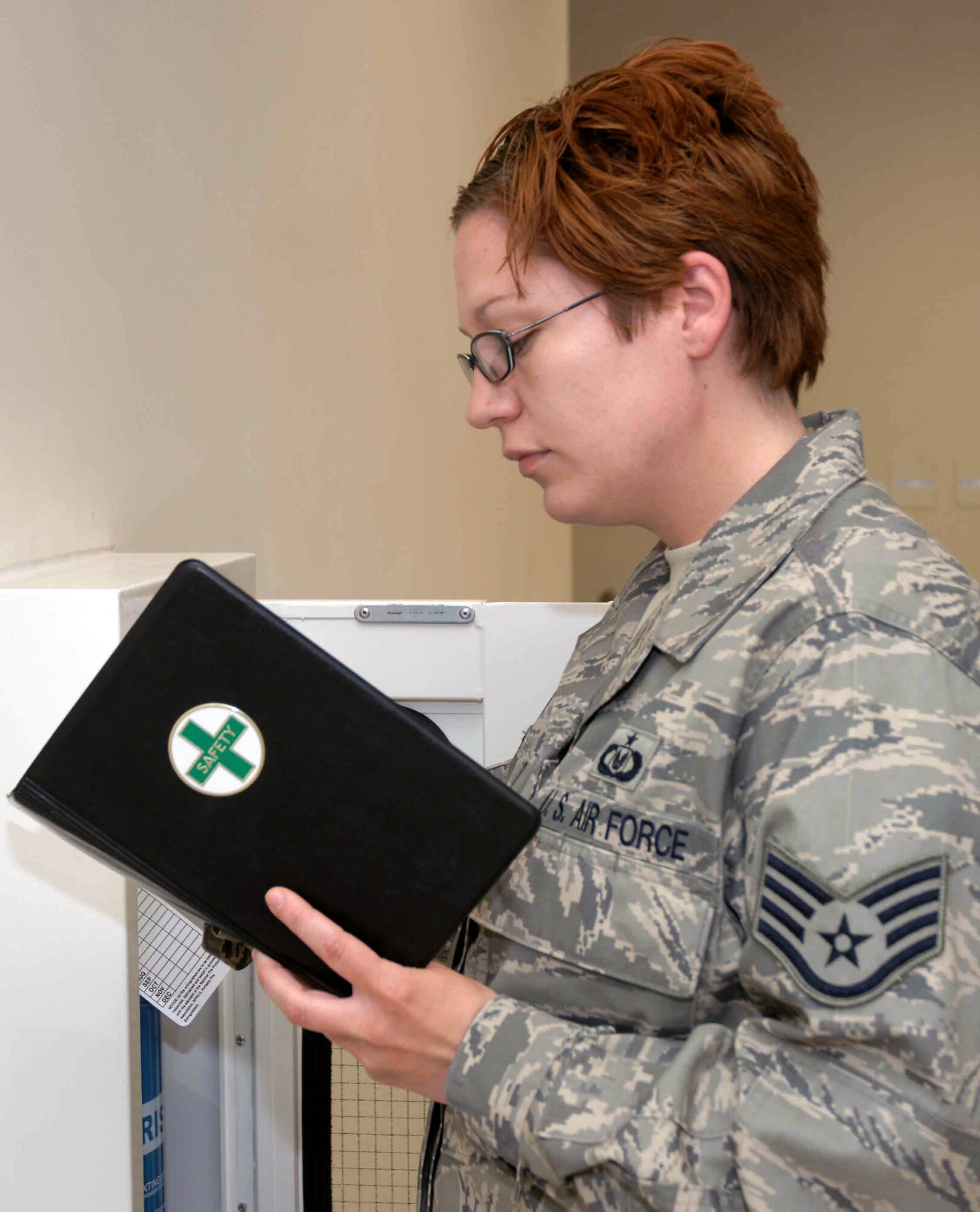 Staff Sgt. Mary Circe checks the expiration and inspection tags on a fire extinguisher June 13 at a base in Southwest Asia. Sergeant Circe is with the 379th Air Expeditionary Wing Ground Safety office. Part of safety office member's duties include frequent spot inspections to ensure units are complying with wing safety regulations. (U.S. Air Force photo/Senior Airman Carolyn Viss) 