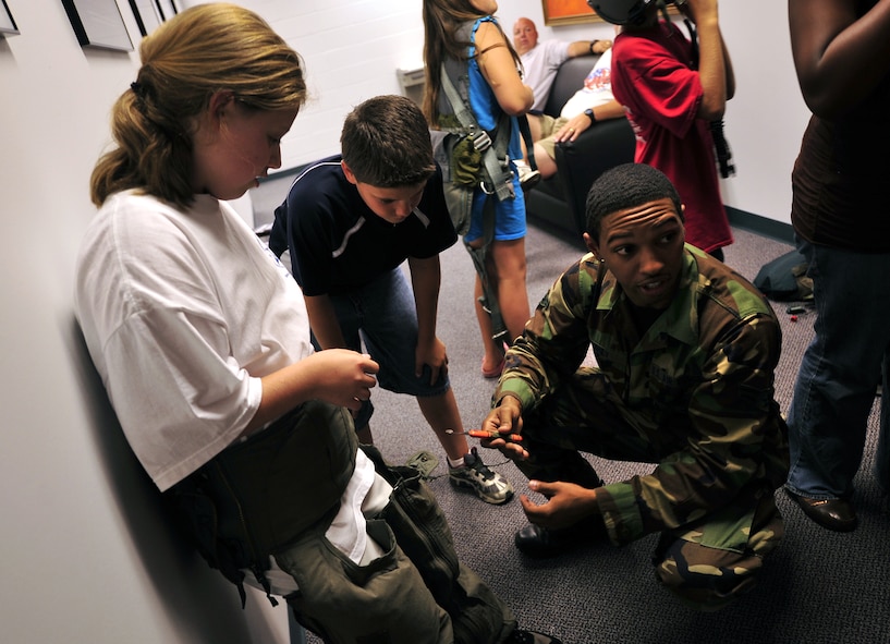 MOODY AIR FORCE BASE, Ga. -- Airman 1st Class Antonio Abney, 23rd Operations Support Squadron aircrew flight equipment apprentice, shows participants of the Lowndes County Sheriff's Office Drug Abuse Resistance Education camp an anti-gravity suit which has a hook blade knife attached to it in a pocket here June 11. The 25 children that participated in the D.A.R.E. camp are fifth grade students from seven elementary schools in the county and are being taught how to avoid drugs and violence while touring many different parts of the community and in turn being introduced to possible career avenues. (U.S. Air Force photo by Senior Airman Elizabeth Rissmiller)