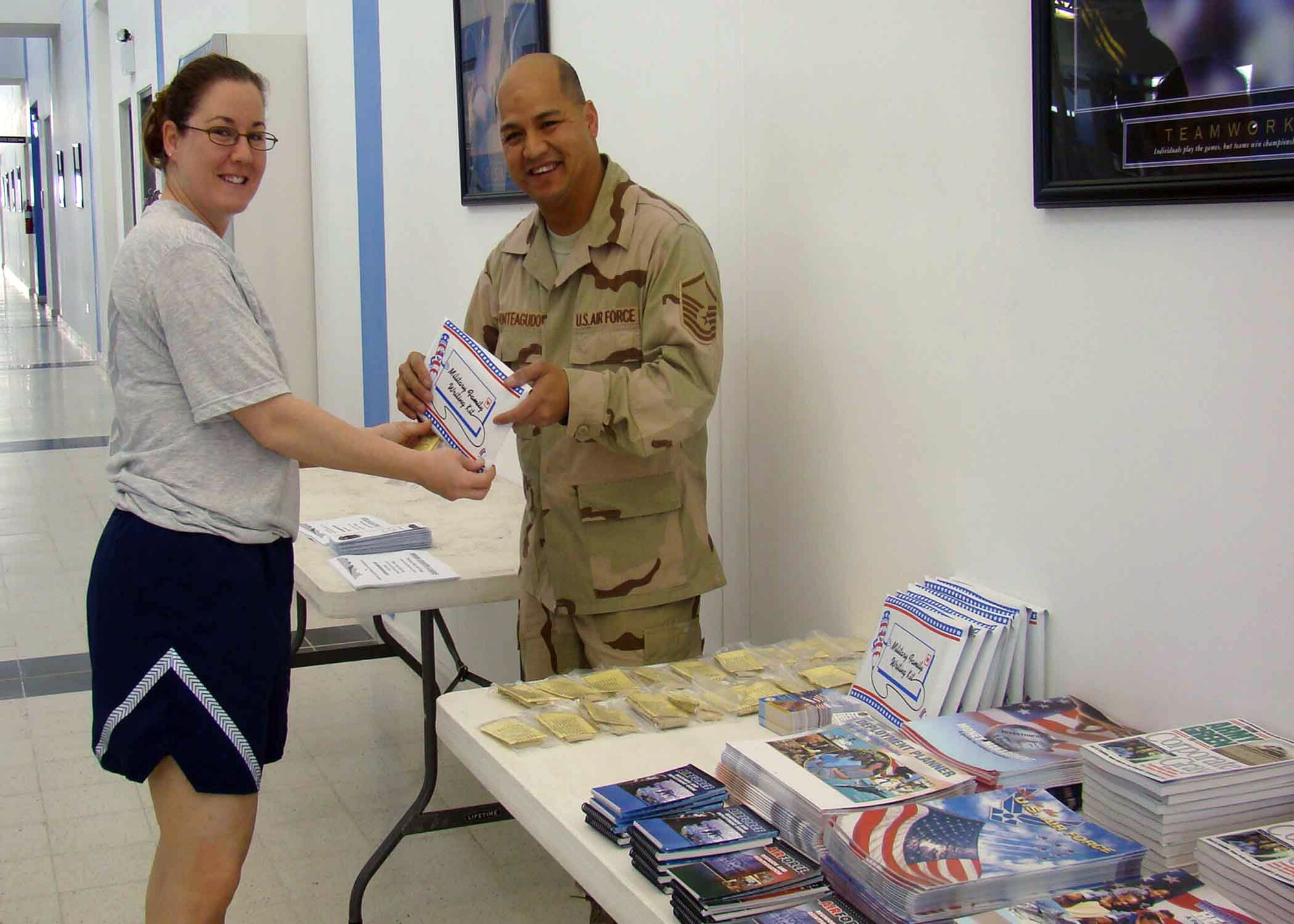 Master Sgt. Meril Monteagudo gives Staff Sgt. Christina Styer information on the Airman Readiness Center's family support services during the Sexual Assault Response Coordinator's Info Fair and 10K Run event titled "Do Something Unreasonable" April 19 at the Blatchford-Preston Complex Fitness Center at a Southwest Asian air base. Sergeant Monteagudo is the Airman Readiness Center superintendent. (Courtesy photo) 
