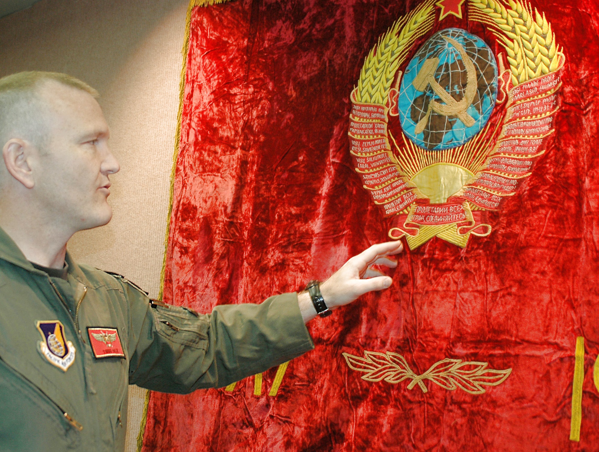 Capt. Todd Hale shows an authentic former Soviet Union flag displayed in the 18th Aggressor Squadron June 9 at Eielson Air Force Base, Alaska. The flag lends to the ambience pilots created to place themselves in the "enemy" mindset for Red Flag-Alaska 08-3. The 18th AGRS chose the pretense of the Soviet Union to emulate since they represented a past threat. Captain Hale is a pilot with the 18th AGRS who obtained the flag during the two years he spent in Russia as a missionary. (U.S. Air Force photo/Airman 1st Class Nora Anton)
