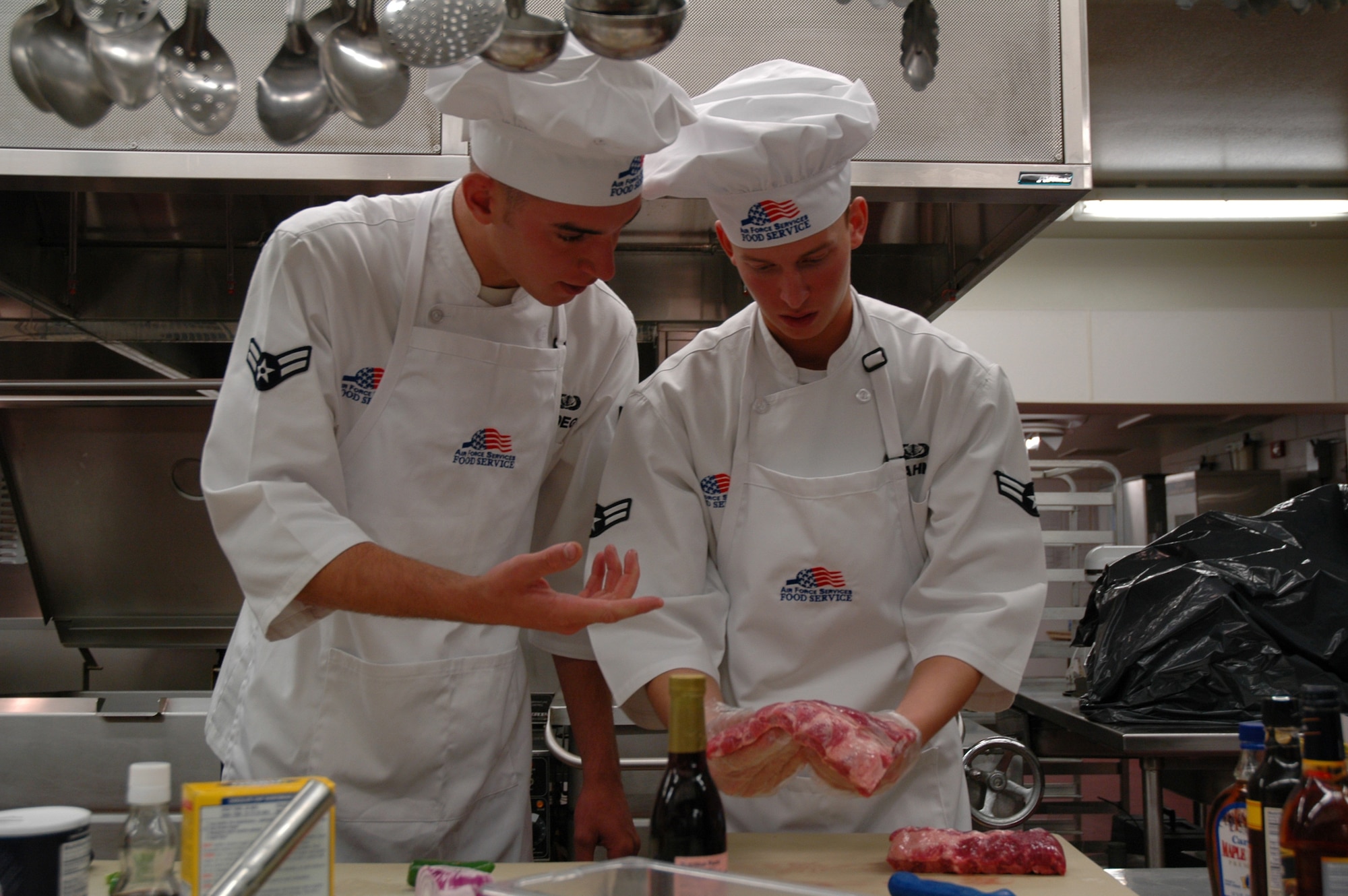 Airman 1st Class Zachary Gloege and Airman 1st Class Brittan Hahn, 490th Missile Squadron, discuss preparation for their baby back ribs during the Warrior Chef competition at the Elkhorn Diner June 10. (U.S. Air Force photo/Airman 1st Class Emerald Ralston) 