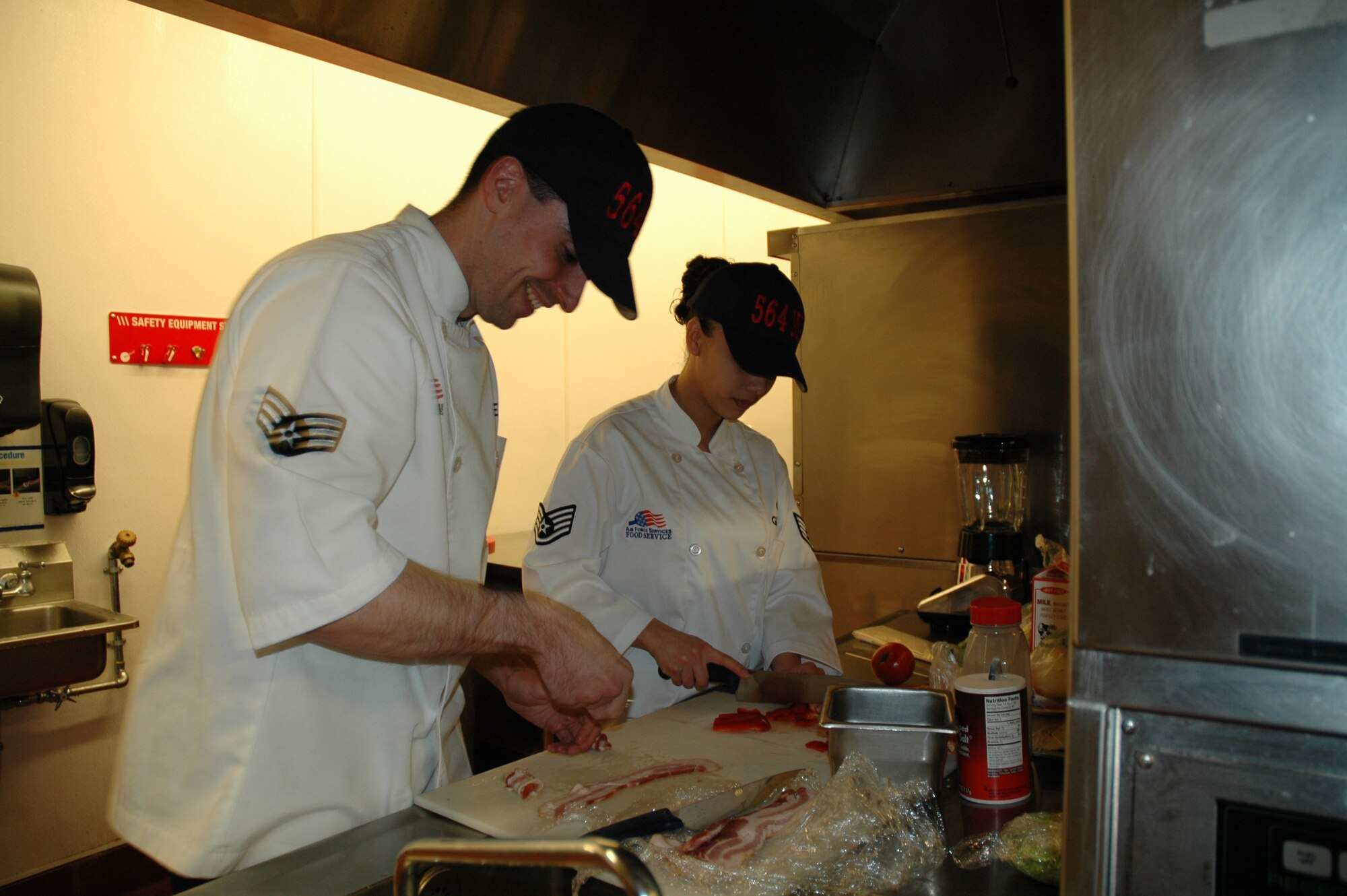 Senior Airman Lyndon Moore and Staff Sgt. Melissa Garrido, 564th Missile Squadron, prepare barbecue shrimp fajitas during the Warrior Chef competition at the Elkhorn Diner June 10. (U.S. Air Force photo/Airman 1st Class Emerald Ralston)