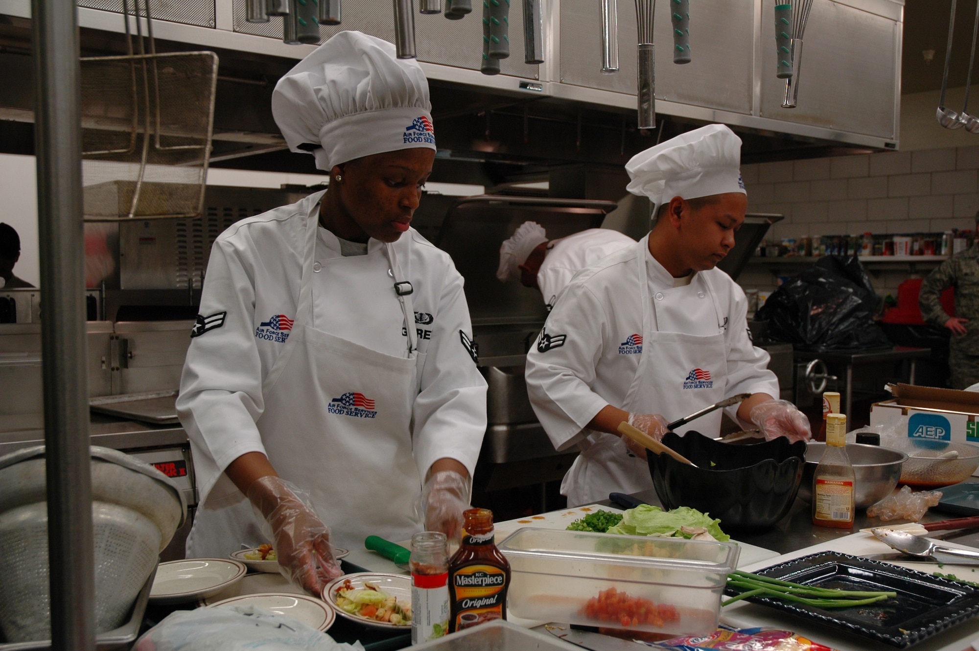 Airman 1st Class Chariesse Garret and Airman 1st Class Marvin Lat, 10th Missile Squadron, prepare their Kobe sesame grilled beef during the Warrior Chef competition at the Elkhorn Diner June 10. (U.S. Air Force photo/Airman 1st Class Emerald Ralston)