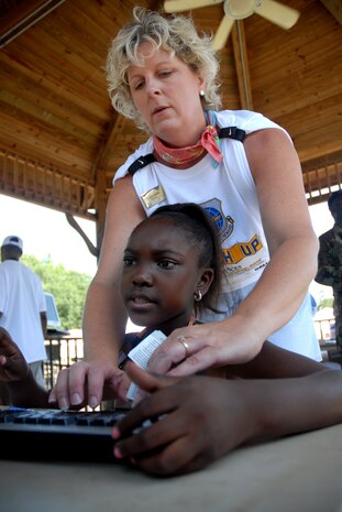 Laura Abell helps Imari Taylor, 9, enroll in Air Mobility Command's MatchUP at the base picnic June 7. Mrs. Abell is the marketing director for the 437th Force Support Squadron and Imari is the daughter of Master Sgt. David Taylor. (U.S. Air Force photo/Senior Airman Sam Hymas)