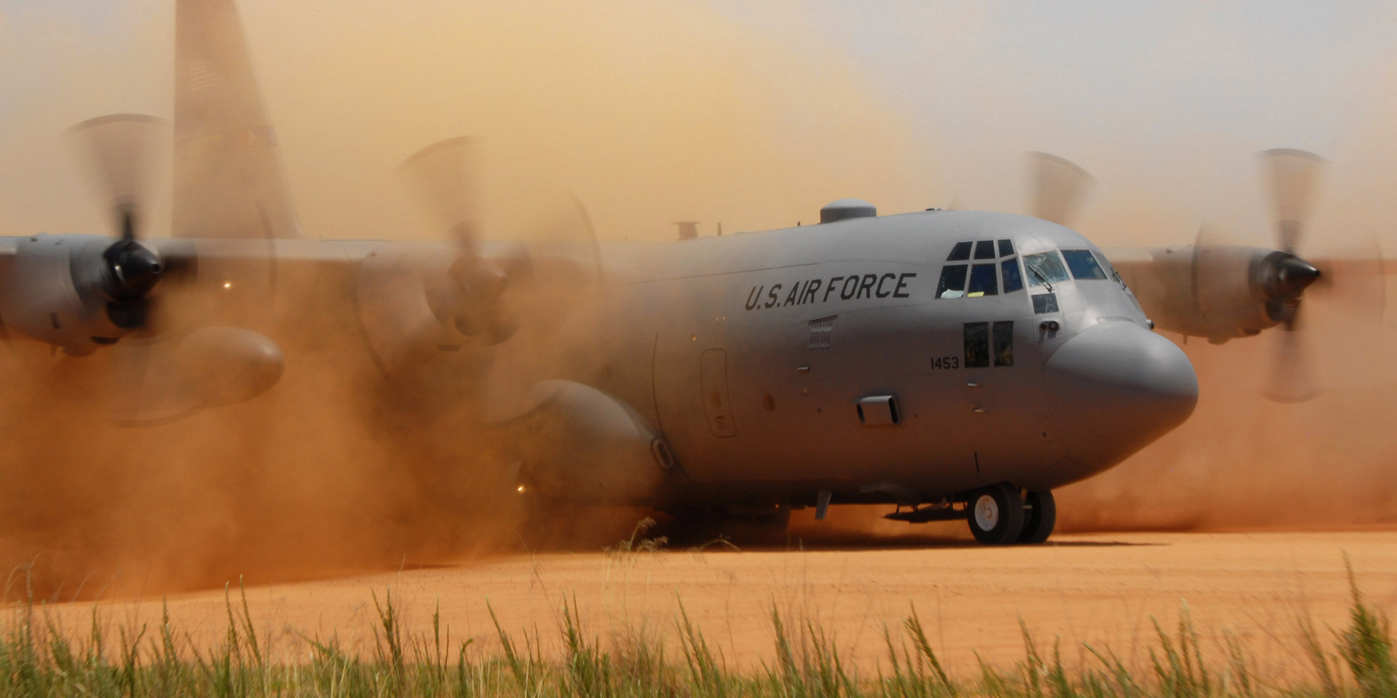 A C-130 Hercules cargo plane performs a tactical landing on a dirt strip at the Sicily Landing Zone on Fort Bragg, N.C. Paratroopers re-enacted a D-Day jump to the zone. The C-130 is assigned to the North Carolina Air National Guard's 145th Wing. (U.S. Air Force photo/Tech. Sgt. Brian E. Christiansen)