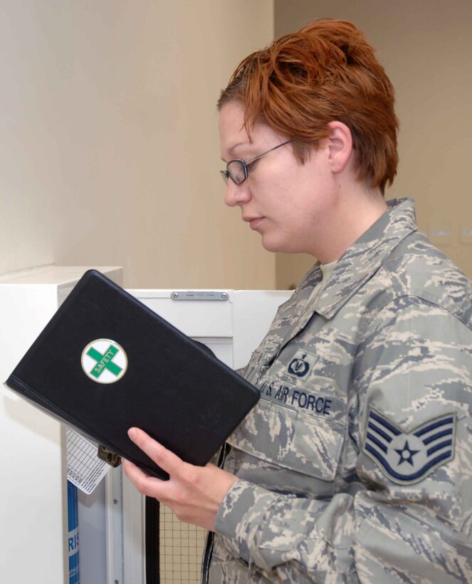 Staff Sgt. Mary Circe, wing ground safety, checks the expiration and inspection tags on a fire extinguisher in the WOC June 13. Part of safety’s duties include  frequent spot inspections to ensure units are complying with wing safety regulations.
 (U.S. Air Force photo/Senior Airman Carolyn Viss)
