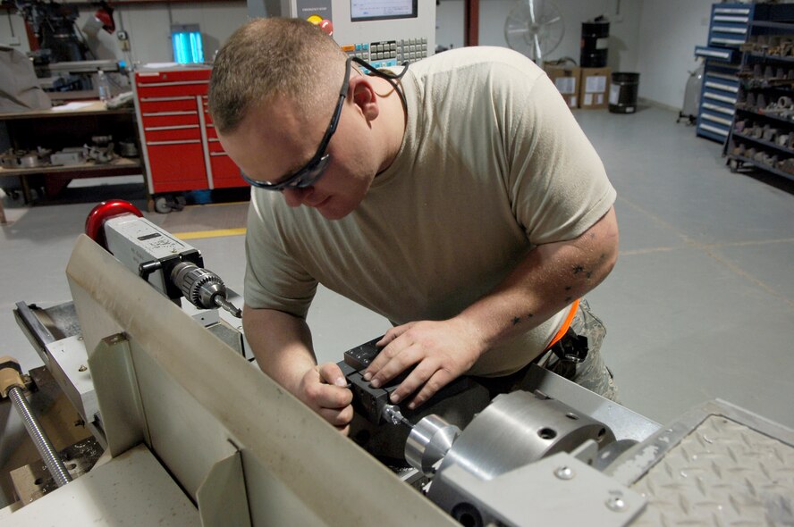 BALAD AIR BASE, Iraq -- Staff Sgt. William Hinkley, a metals technologist assigned to the 332nd Expeditionary Aircraft Maintenance Squadron fabrication flight, fashions a piece of metal into an aircraft component using a computer numerical controlled lathe here, June 10. The CNC lathe allows the Airmen to enter and store codes into the machine that tells it the dimensions the component should be. The Fabrication Flight Airmen fix and build aircraft components needed to fly F-16s, C-130s, unmanned aerial vehicles, helicopters and Army assets. Sergeant Hinkley is deployed from Hill Air Force Base, Utah. (U.S. Air Force photo /Staff Sgt. John Ayre)