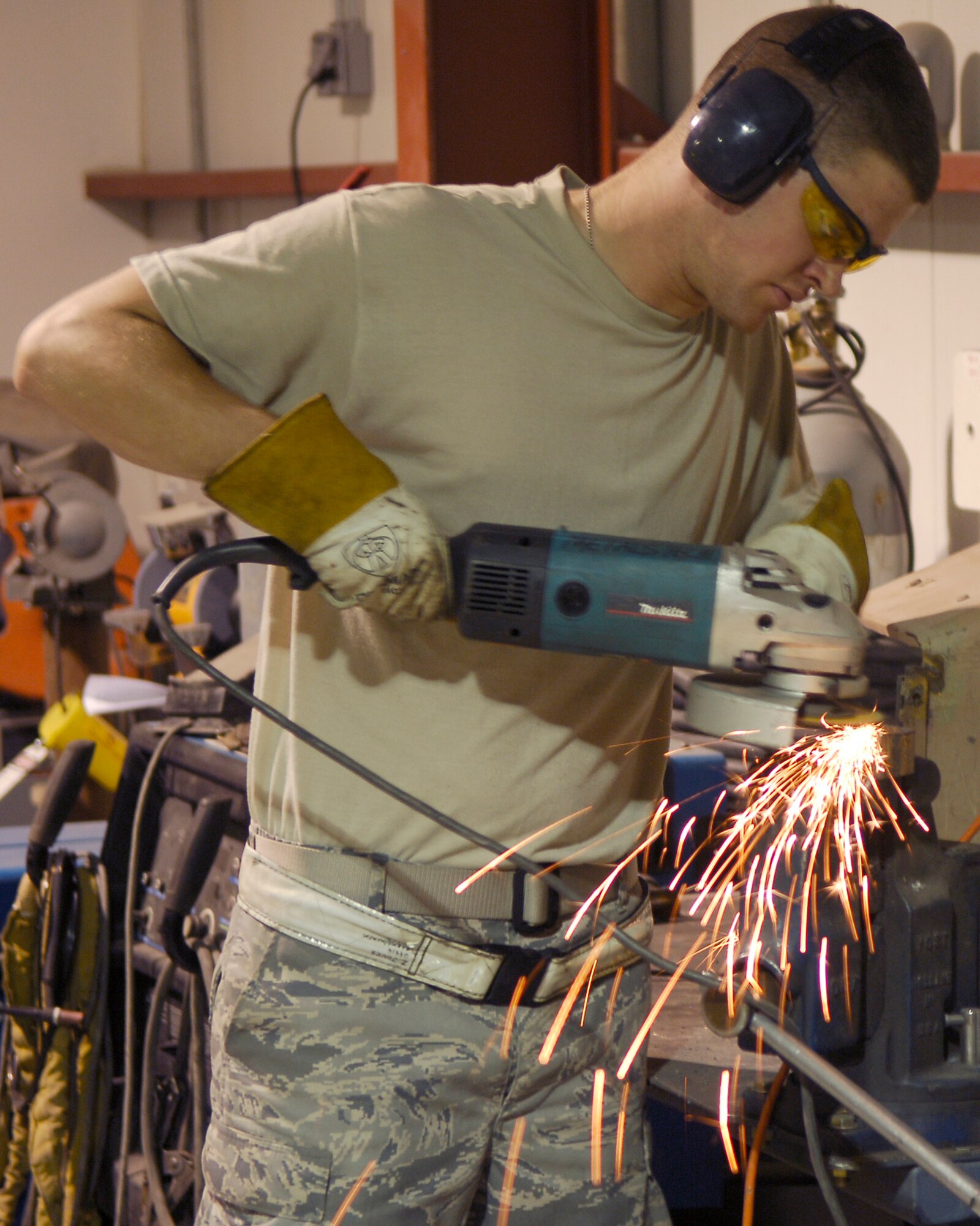 BALAD AIR BASE, Iraq -- Sparks fly as Senior Airman Zach Jones, a structural maintenance welder assigned to the 332nd Expeditionary Aircraft Maintenance Squadron Fabrication Flight, uses a power saw to manipulate a piece of metal here, June 10. The structural maintenance Airmen are responsible for maintaining and repairing anything pertaining to the structure of aircraft, such as wings, panels and hinges. More than 50 active-duty, Reserve and Air National Guard Airmen run the Fabrication Flight shop 24/7 and complete more than 1,400 jobs monthly. Airmen Jones is deployed from Shaw Air Force Base, S.C.  (U.S. Air Force photo /Staff Sgt. John Ayre)
