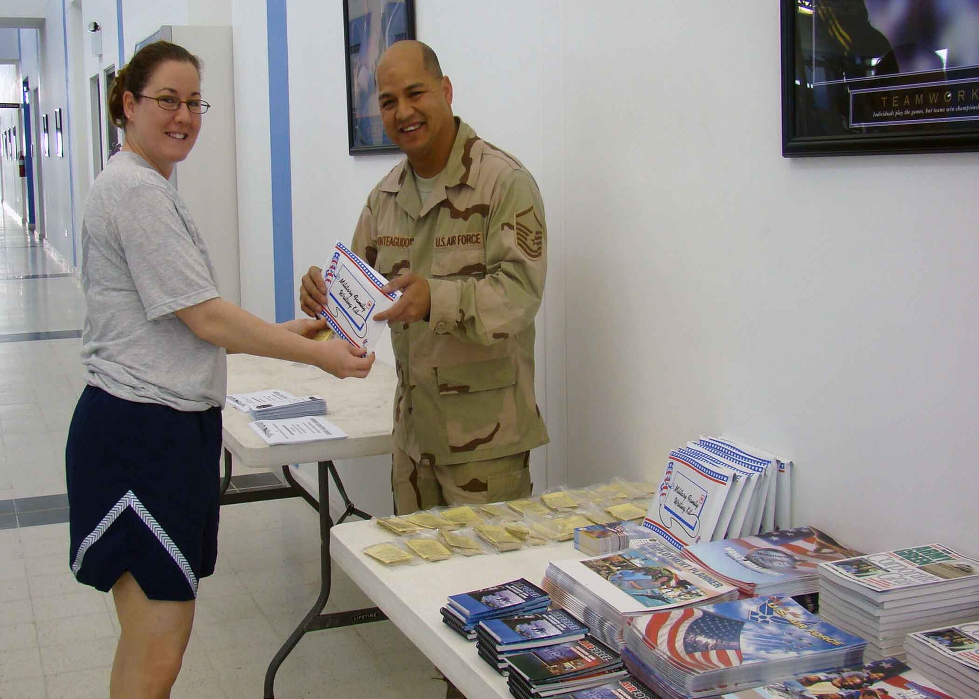 SOUTHWEST ASIA -- Master Sgt. Meril Monteagudo, Airman Readiness Center superintendent, gives Staff Sgt. Christina Styer information on the ARC's family support services during the Sexual Assault Response Coordinator's Info Fair and 10K Run event titled "Do Something Unreasonable" April 19 at the Blatchford-Preston Complex Fitness Center. (Courtesy photo)