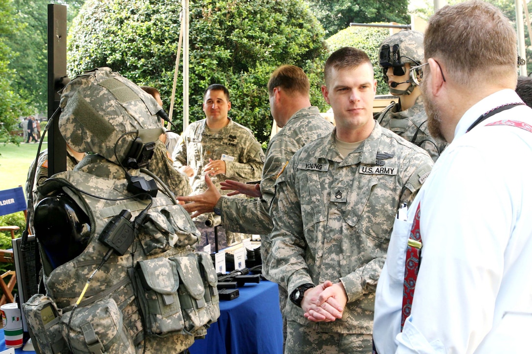 Army Staff Sgt. James Young, explains the Land Warrior System attached to his body armor and helmet to people attending the Program Executive Office Soldier display in the Pentagon Courtyard June 13, 2008.  Brown is a squad leader assigned to 4th Battalion, 9th Infantry Regiment, 4th Stryker Brigade Combat Team, 2nd Infantry Division. Defense Dept. photo by Army Staff Sgt. Michael J. Carden