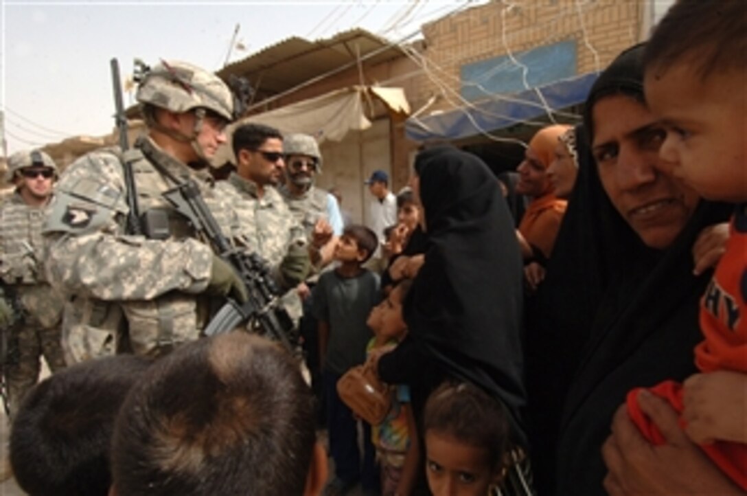 U.S. Army Capt. Goettke from the 320th Battalion, 3rd Brigade Combat Team, 101st Airborne Division talks to Iraqis in a market scheduled for renovation in Mahmudiyah, Iraq, on June 9, 2008.  