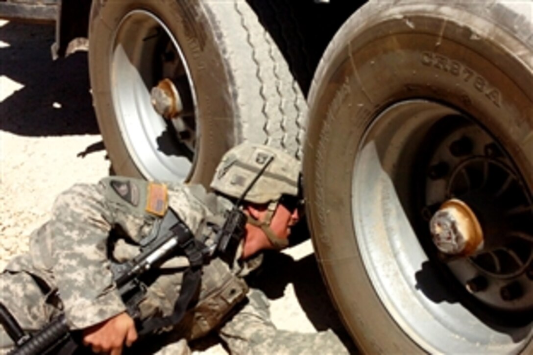 U.S. Army Spc. Chad Fawcett inspects trucks prior to an Army convoy movement, June 4, 2008, Trebil, Iraq. Fawcett is assigned to the 266th Movement Control Team.

