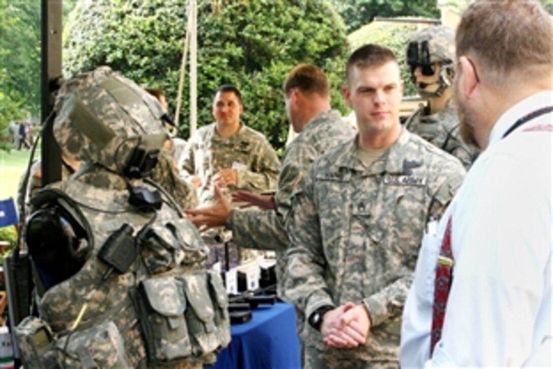 Army Staff Sgt. James Young explains the Land Warrior System attached to his body armor and helmet to people attending the Program Executive Office clothing and equipment display June 13, 2008, at the Pentagon courtyard. Young serves as a squad leader with 4th Battalion, 9th Infantry Regiment, 4th Stryker Brigade Combat Team, 2nd Infantry Division, Fort Lewis, Wash.