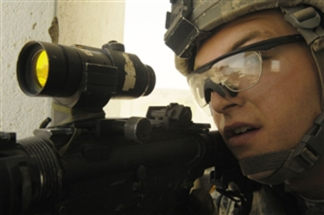 U.S. Army Pfc. Smith from the 10th Mountain Division Military Police provides rooftop security for his dismounted teammates during a routine inspection of a local Iraqi police station at Ad Diwaniyah, Iraq, on June 10, 2008.  