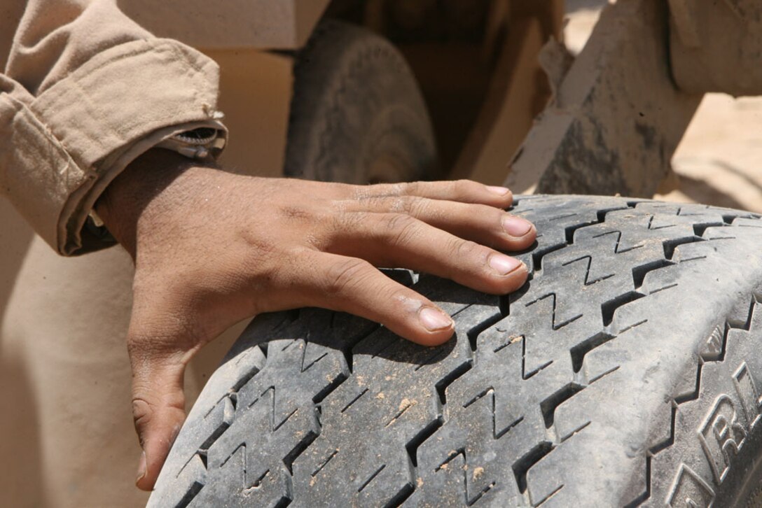 Lance Cpl. Enoch E. Chavarria, 21, a combat engineer with Route Clearance Platoon, 3rd Combat Engineer Battalion, Regimental Combat Team 5, visually inspects a tire on a vehicle in Rawah, Iraq, June 12. The platoon travels RCT-5's area of operations to clear the roadways of any dangers that may cause harm to Coalition forces and Iraqi civilians.