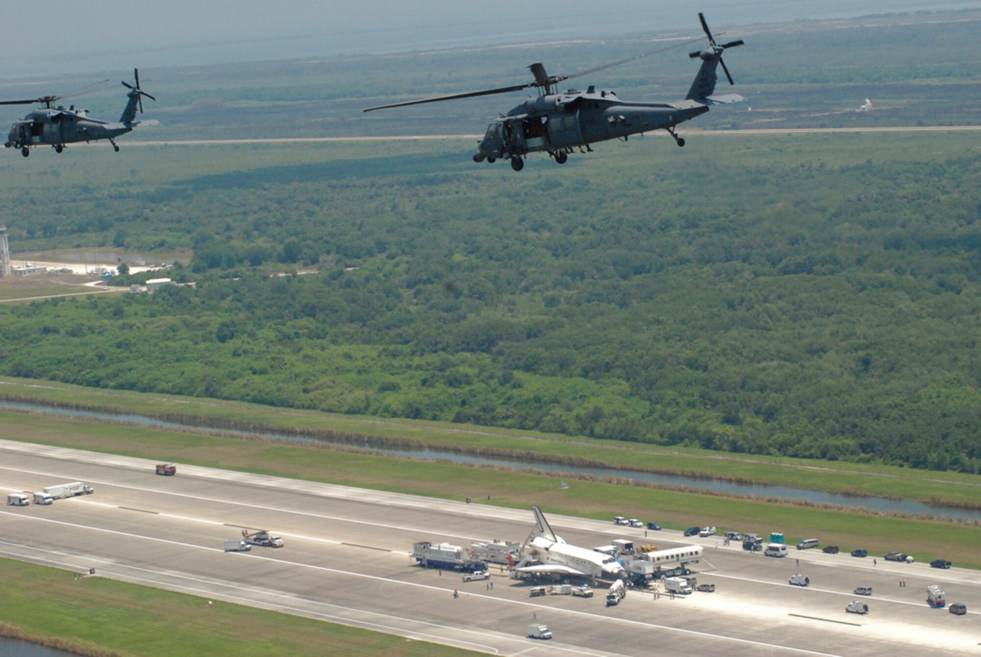 CAPE CANAVERAL AIR FORCE STATION, Fla. -- Two 920th Rescue Wing HH-60G Pavehawk helicopters fly over Space Shuttle Discovery June 14 moments after its safe return from the International Space Station.  In addition to their military mission, Air Force Reservists from the 920th provide rescue and recovery support for all shuttle launches and landings.  (U.S. Air Force Photo/Tech. Sgt. Jeremy Allen).